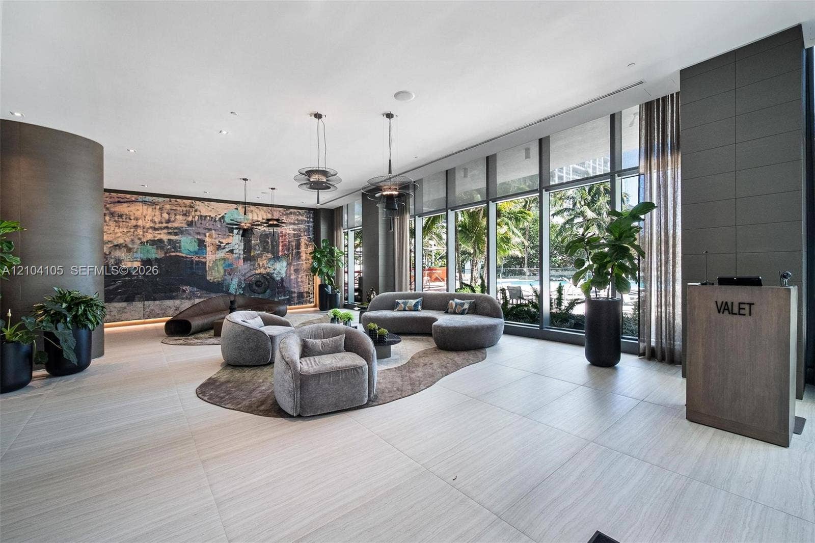 Expansive floor-to-ceiling windows, light-toned tile flooring, recessed ceiling lighting, and a valet station