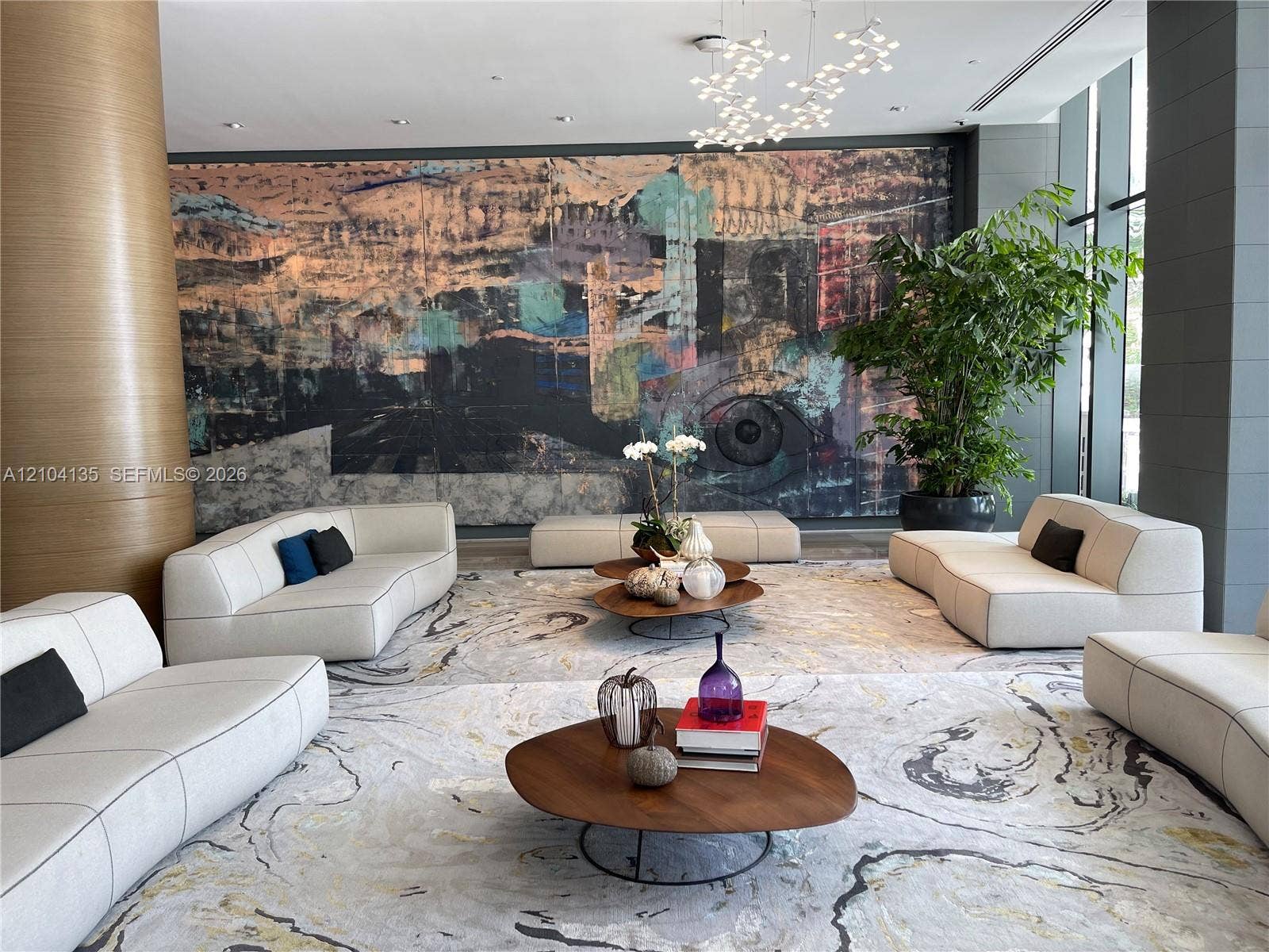 Lobby featuring floor-to-ceiling accent wall, multi-tiered sculptural light fixture, and floor-to-ceiling windows