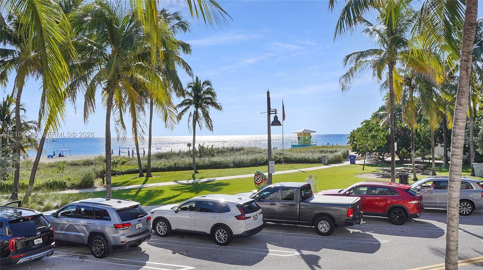 111 N Pompano Beach Boulevard, #304, Pompano Beach, FL 33062 Public park grounds featuring mature palm trees, manicured lawn areas, and direct sandy beach access