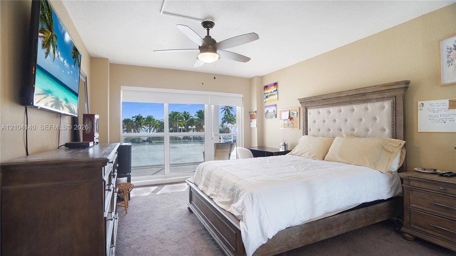 111 N Pompano Beach Boulevard, #304, Pompano Beach, FL 33062 Bedroom featuring carpeted flooring, a ceiling fan with integrated lighting, and expansive floor-to-ceiling glass sliding doors with an exterior balcony