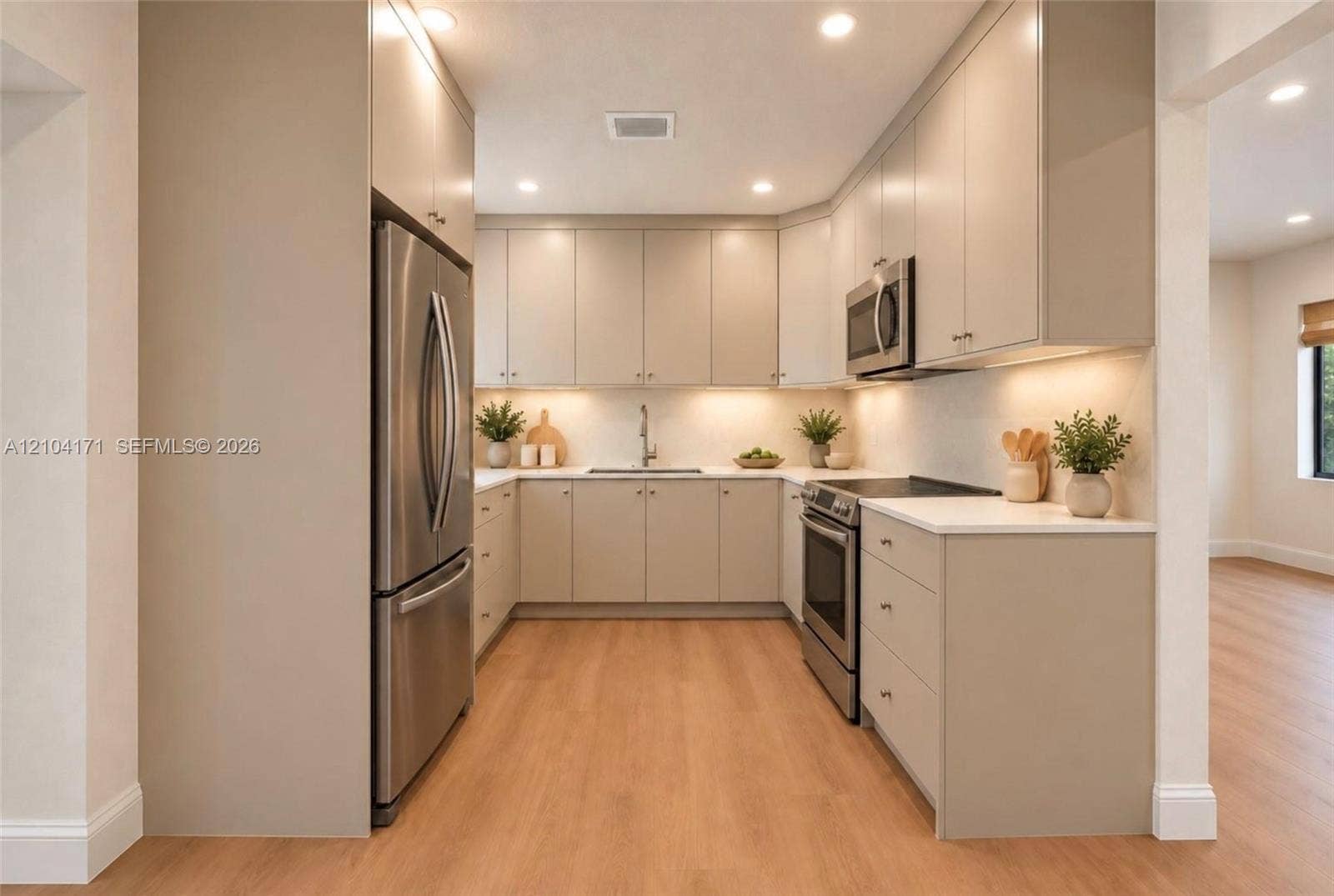 745 NW 32nd Avenue, Miami, FL 33125 Kitchen featuring flat-panel cabinetry, light-toned countertops, recessed lighting, and stainless steel appliances including a refrigerator, range, and microwave