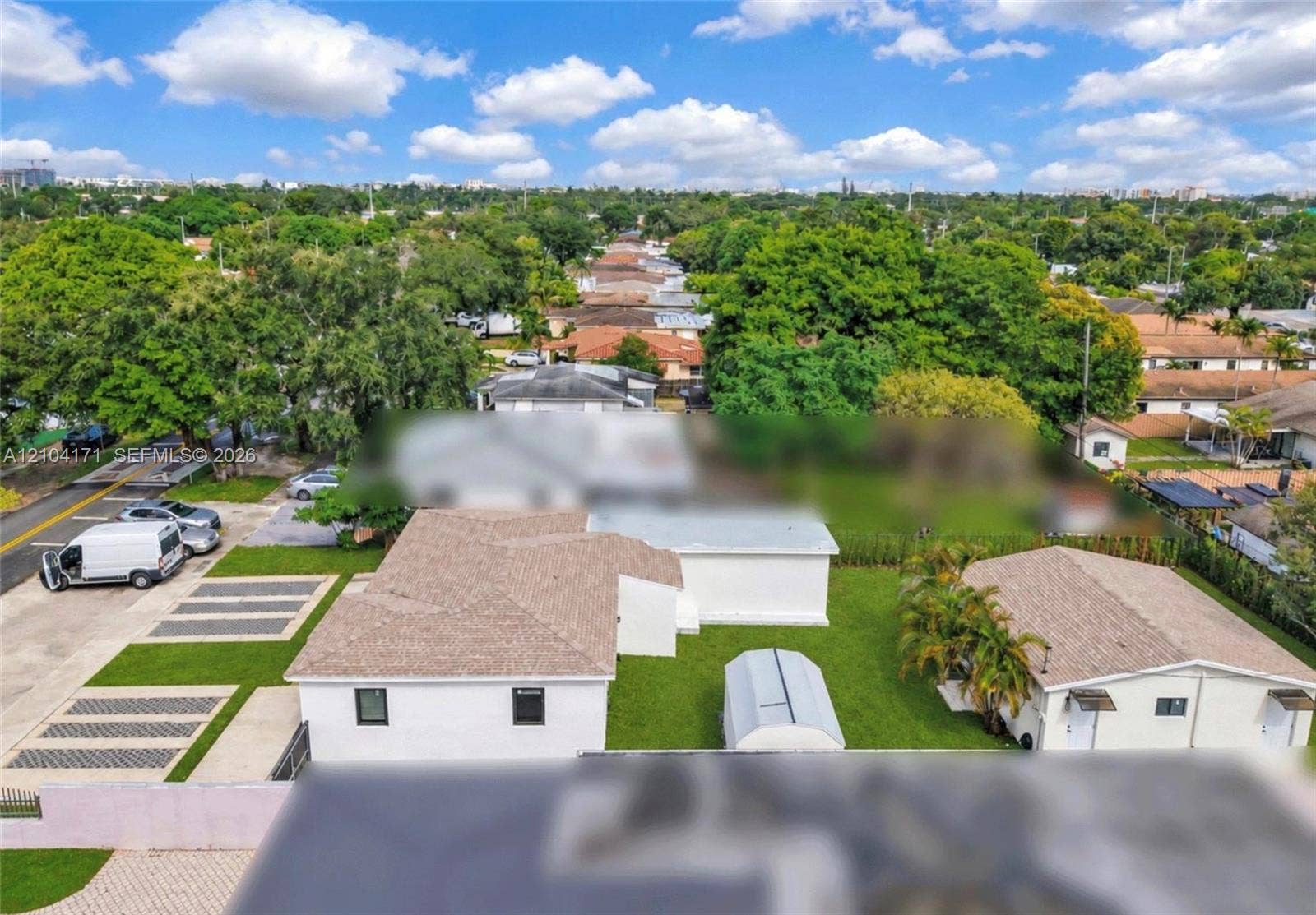 745 NW 32nd Avenue, Miami, FL 33125 Aerial perspective featuring a detached structure, paved multi-vehicle parking area, and expansive lawn space