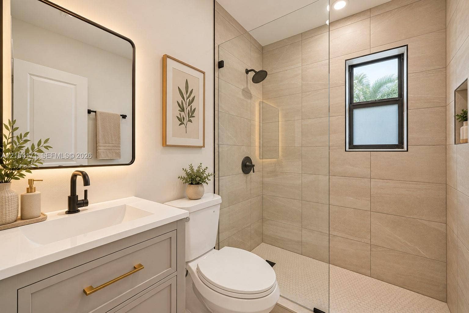 745 NW 32nd Avenue, Miami, FL 33125 Bathroom featuring a light grey vanity with a white countertop, matte black fixtures, a walk-in shower with floor-to-ceiling tile, and a backlit rectangular mirror
