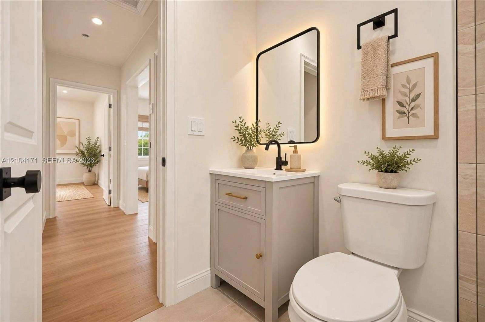745 NW 32nd Avenue, Miami, FL 33125 Grey vanity with a light-toned countertop, rectangular undermount sink, matte black faucet, and backlit rectangular mirror