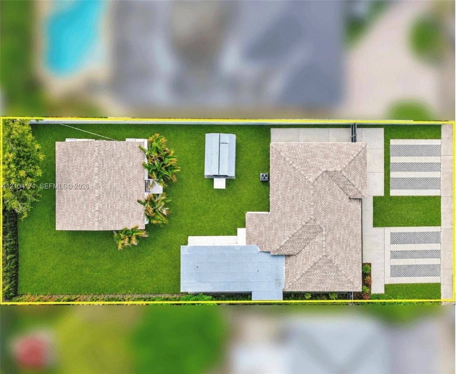 745 NW 32nd Avenue, Miami, FL 33125 Aerial view of property featuring a detached structure, manicured lawn, paved driveway, and perimeter fencing