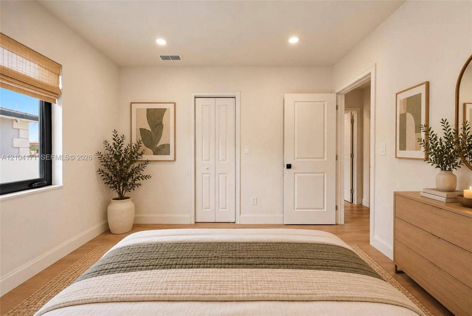 745 NW 32nd Avenue, Miami, FL 33125 Neutral-toned interior featuring wood-finish flooring, recessed lighting, a single window with black framing, a bi-fold closet, and a multi-panel interior door with matte black hardware
