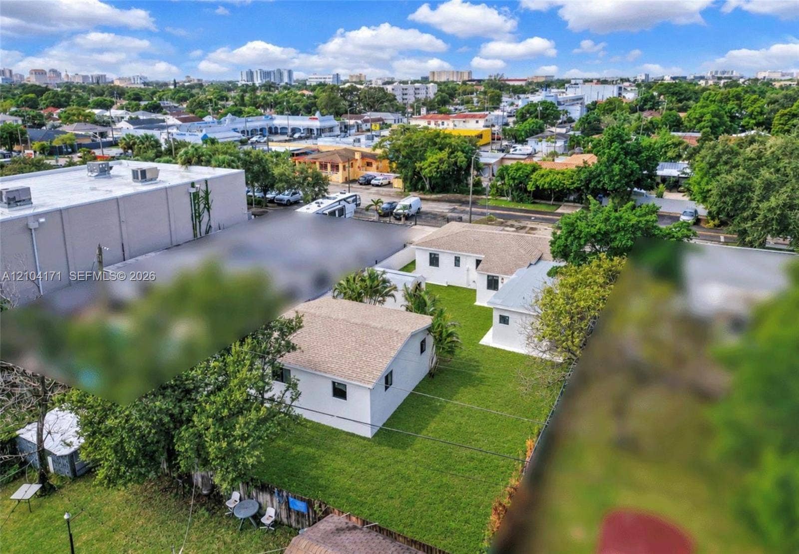 745 NW 32nd Avenue, Miami, FL 33125 Aerial perspective of property featuring multiple structures, expansive green space, mature landscaping, and perimeter fencing