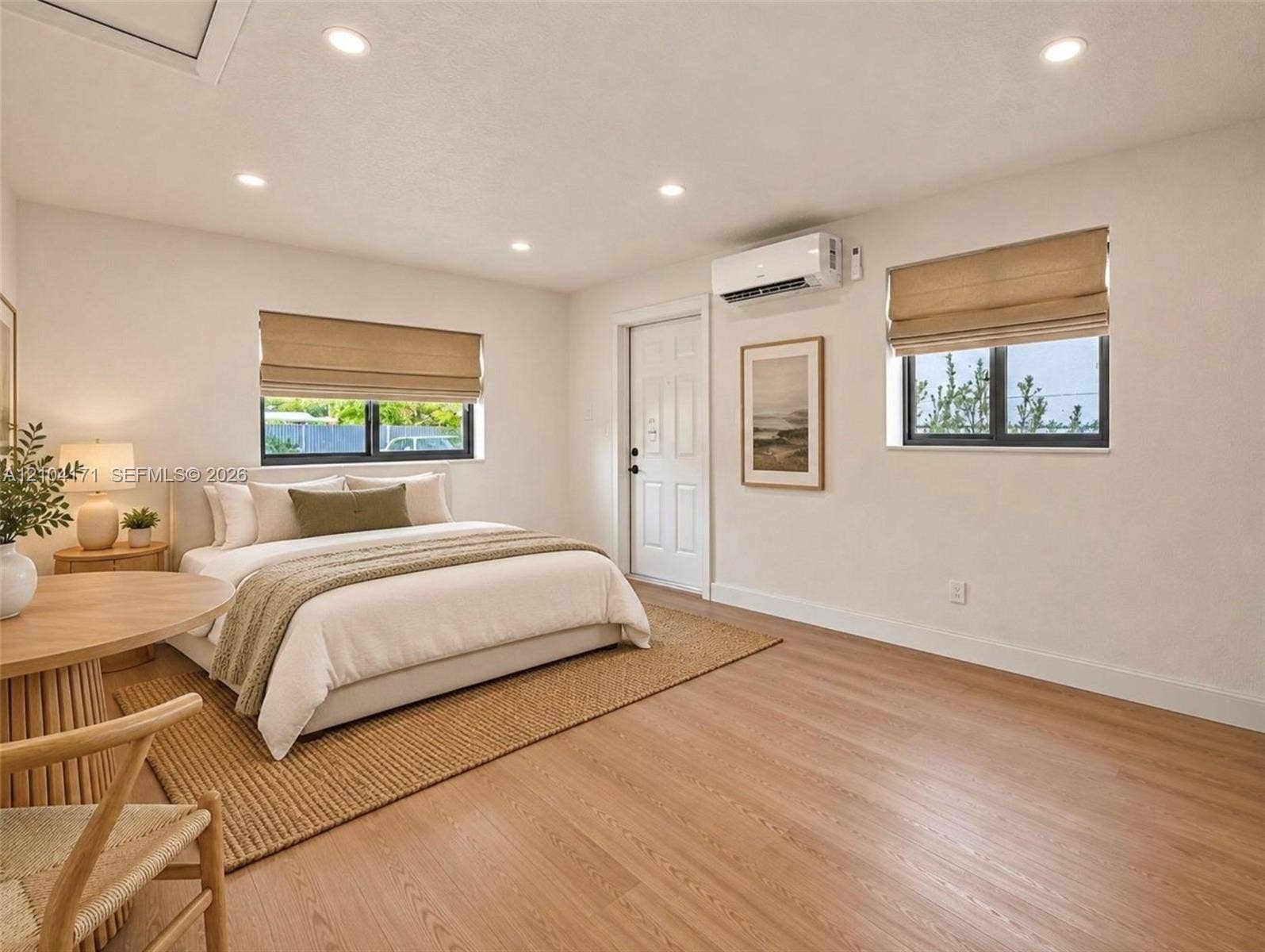 745 NW 32nd Avenue, Miami, FL 33125 Wood-finish flooring, recessed lighting, dual windows with Roman shades, and a wall-mounted ductless mini-split system