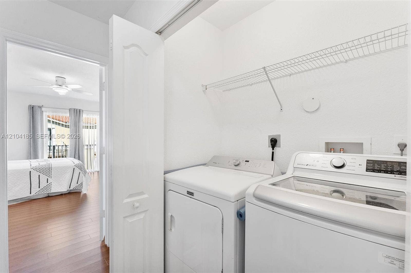 Dedicated laundry area featuring a white wire shelving unit and hookups for appliances
