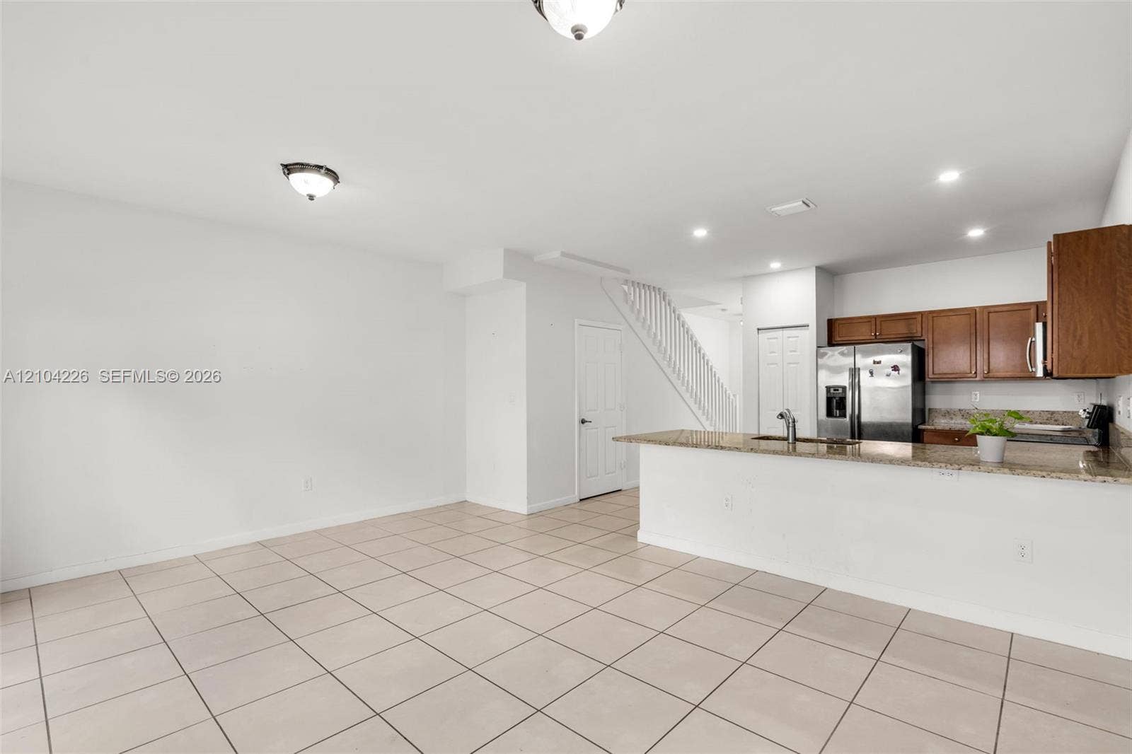 11555 SW 248th Lane, Homestead, FL 33032 Kitchen featuring stone-finish countertops, stainless steel appliances, and wood-finish cabinetry, complemented by tile flooring and recessed lighting