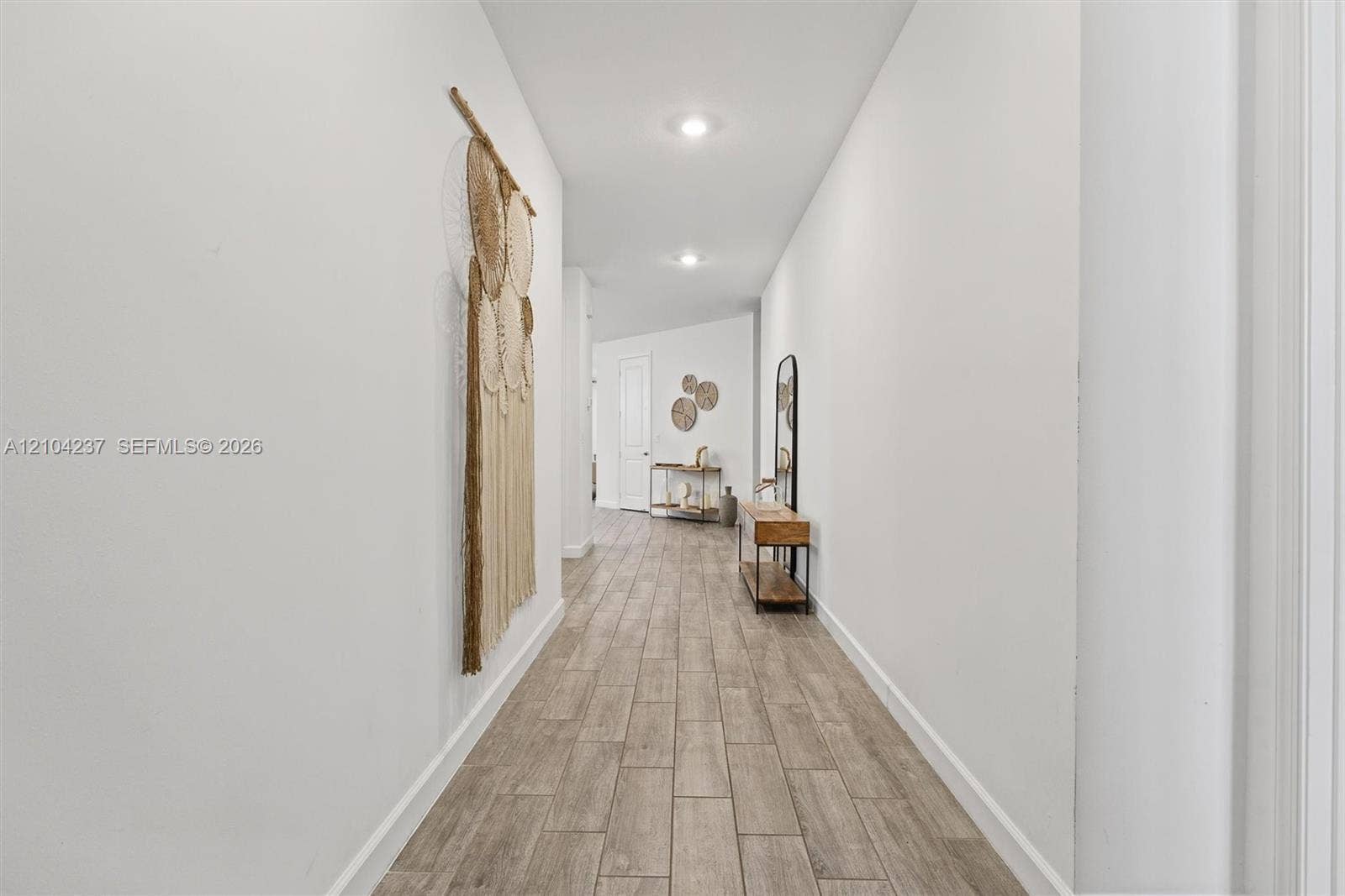 Hallway featuring neutral-toned wall-finish flooring and recessed ceiling lighting