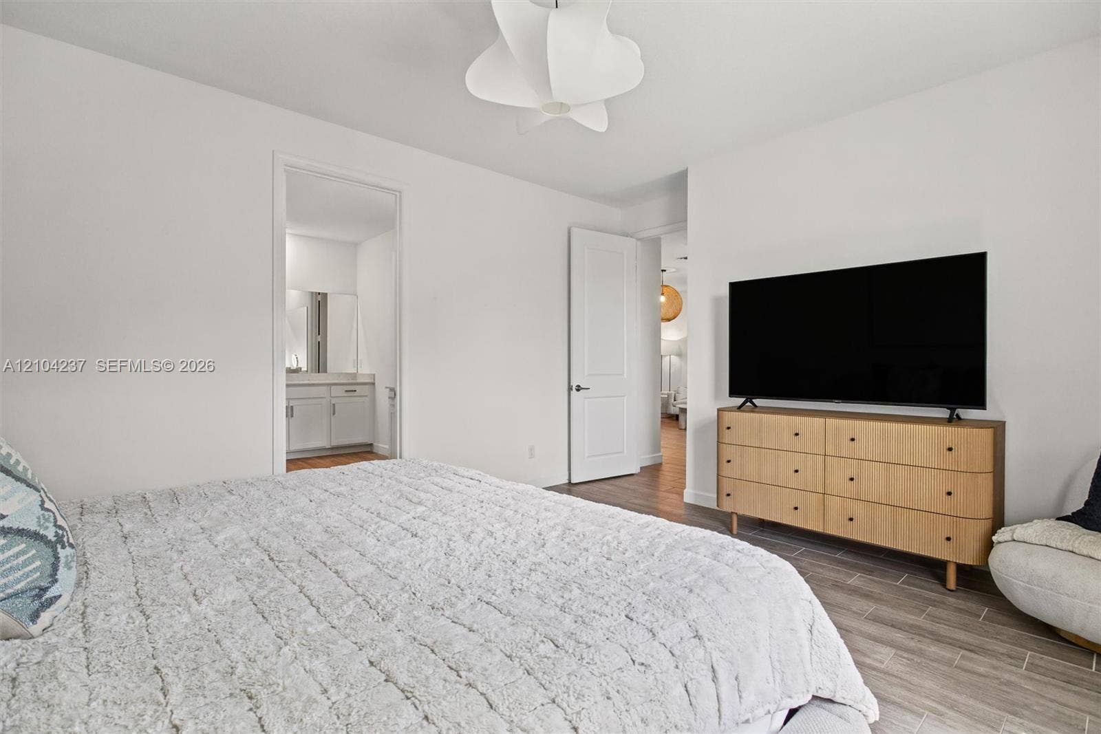 Neutral interior featuring wood-finish tile flooring, a multi-faceted flush-mount light fixture, and two-panel interior doors