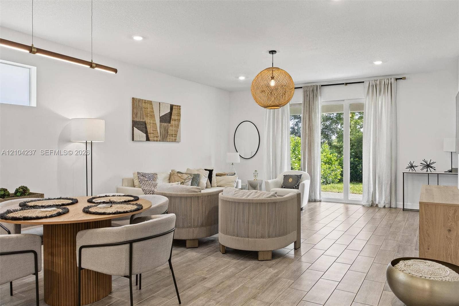 Open-concept area featuring wood-finish tile flooring, recessed lighting, a linear metal chandelier, and floor-to-ceiling glass sliding doors