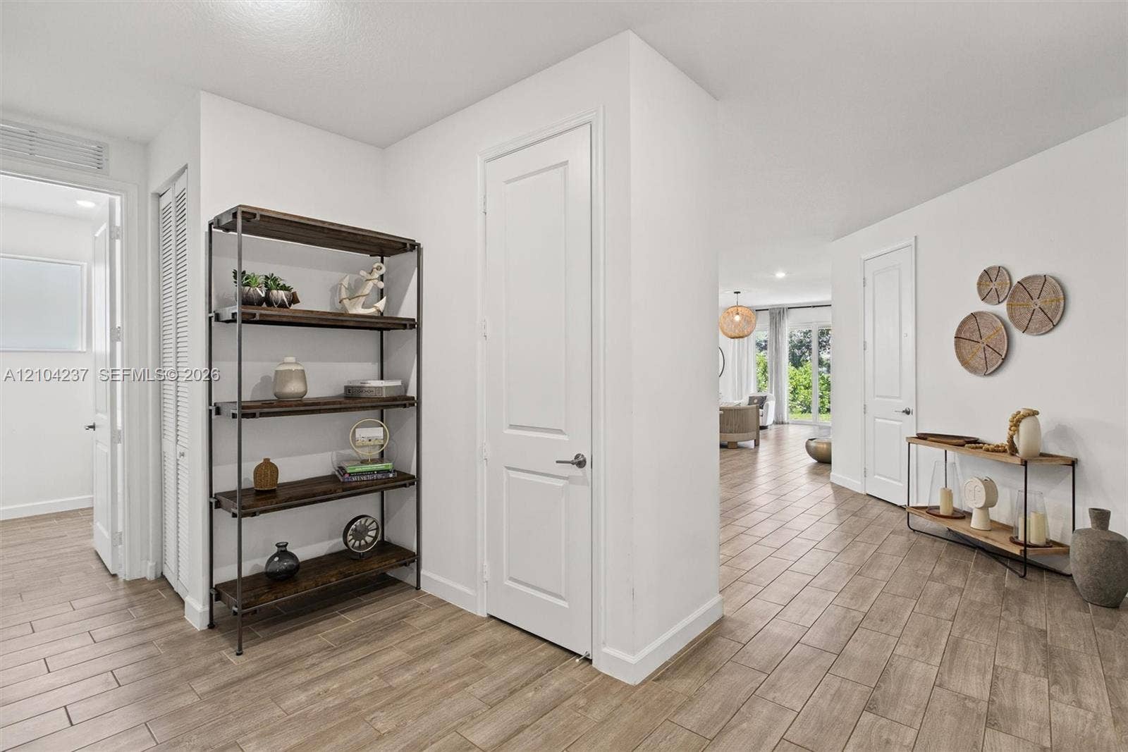 Neutral-toned wood-finish flooring, white panel interior doors, and clean-finished walls
