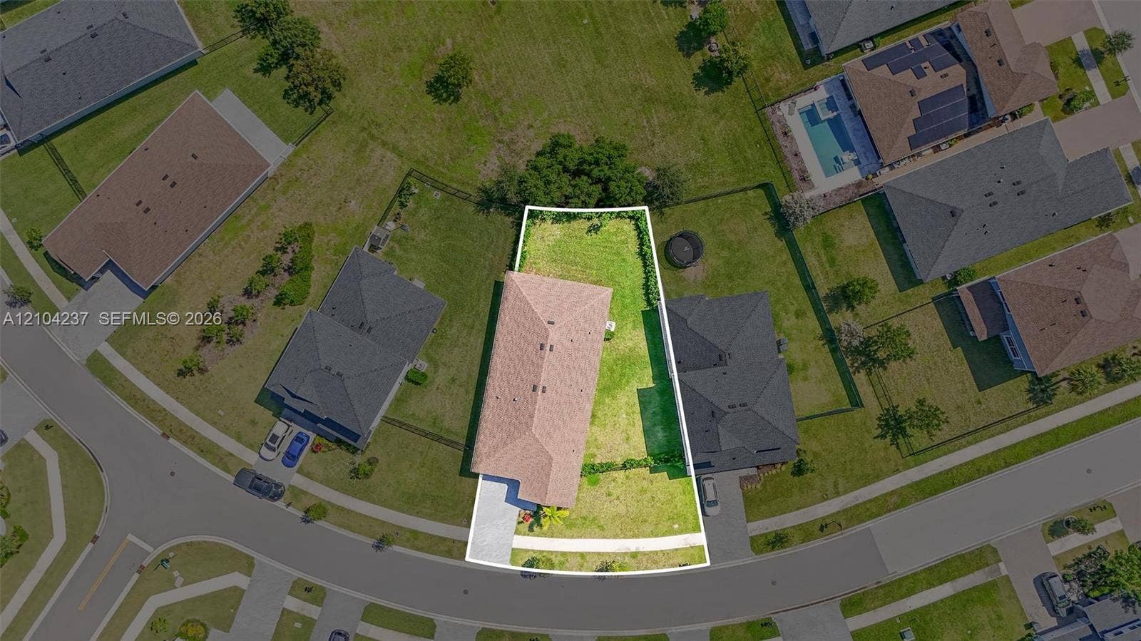 Aerial view of property on a cul-de-sac lot, featuring an expansive backyard, perimeter fencing, and concrete driveway