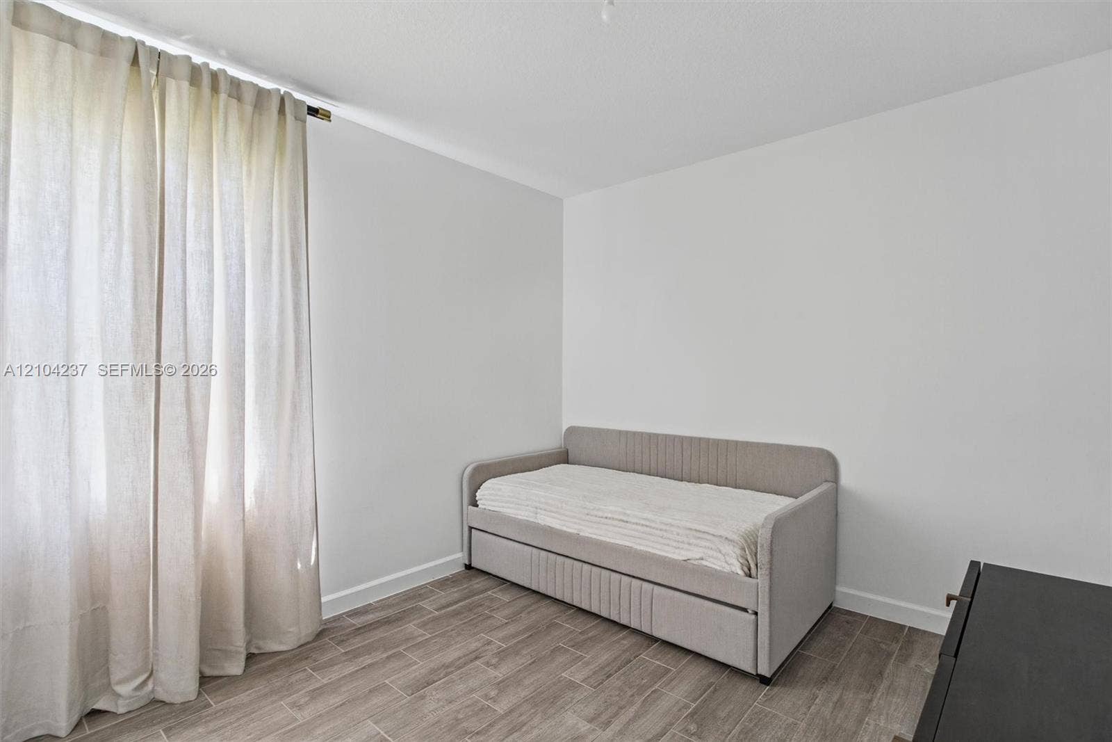 Neutral-toned wall finish with wood-finish tile flooring