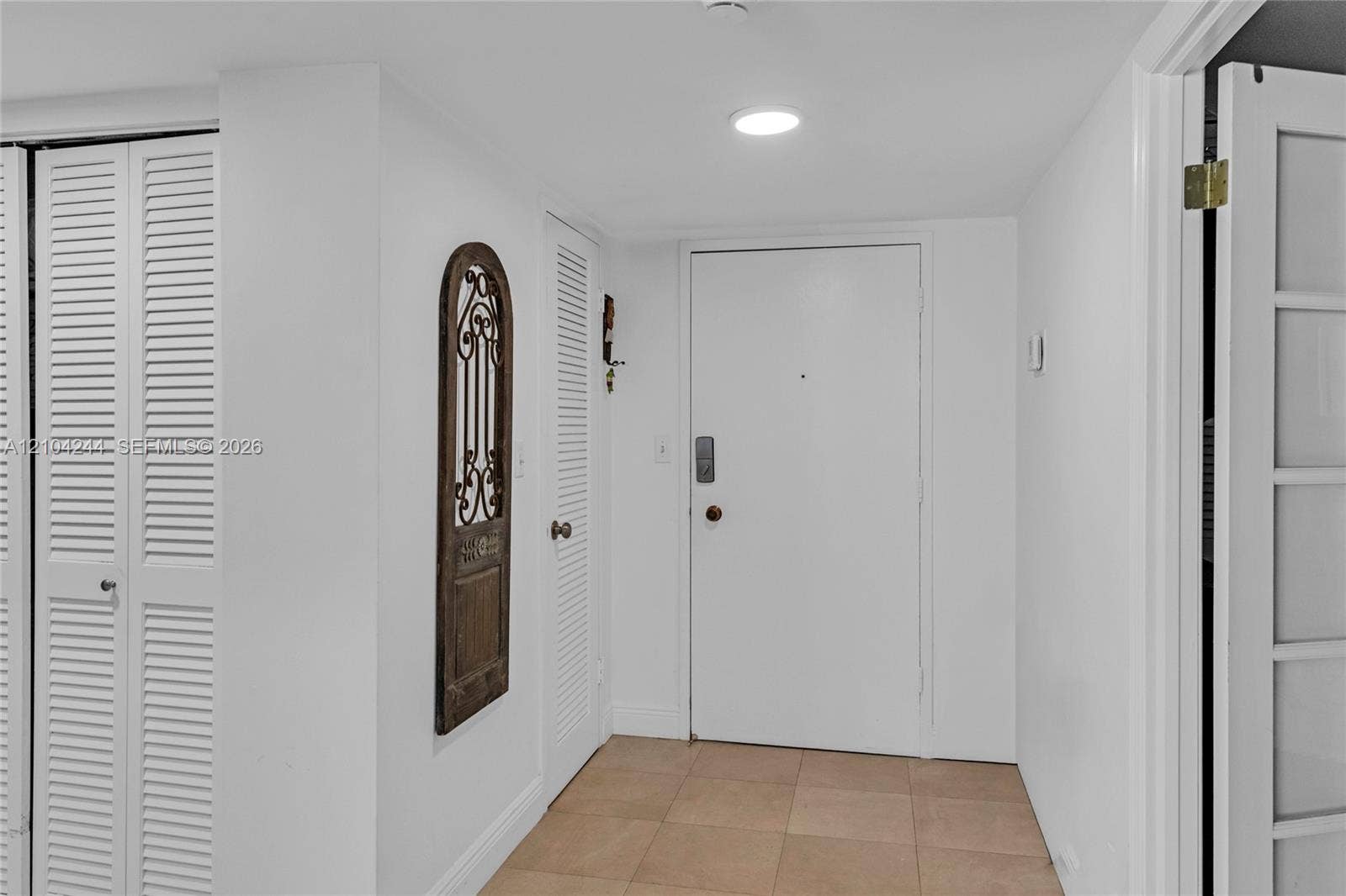 Foyer featuring neutral tile flooring, recessed lighting, and white louvered closet doors
