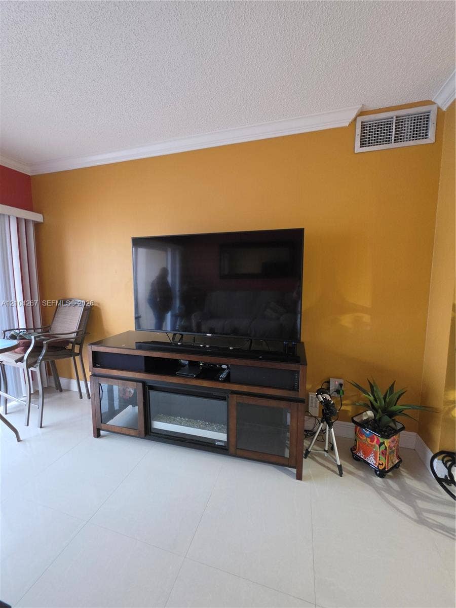 Interior space featuring white tile flooring and crown molding