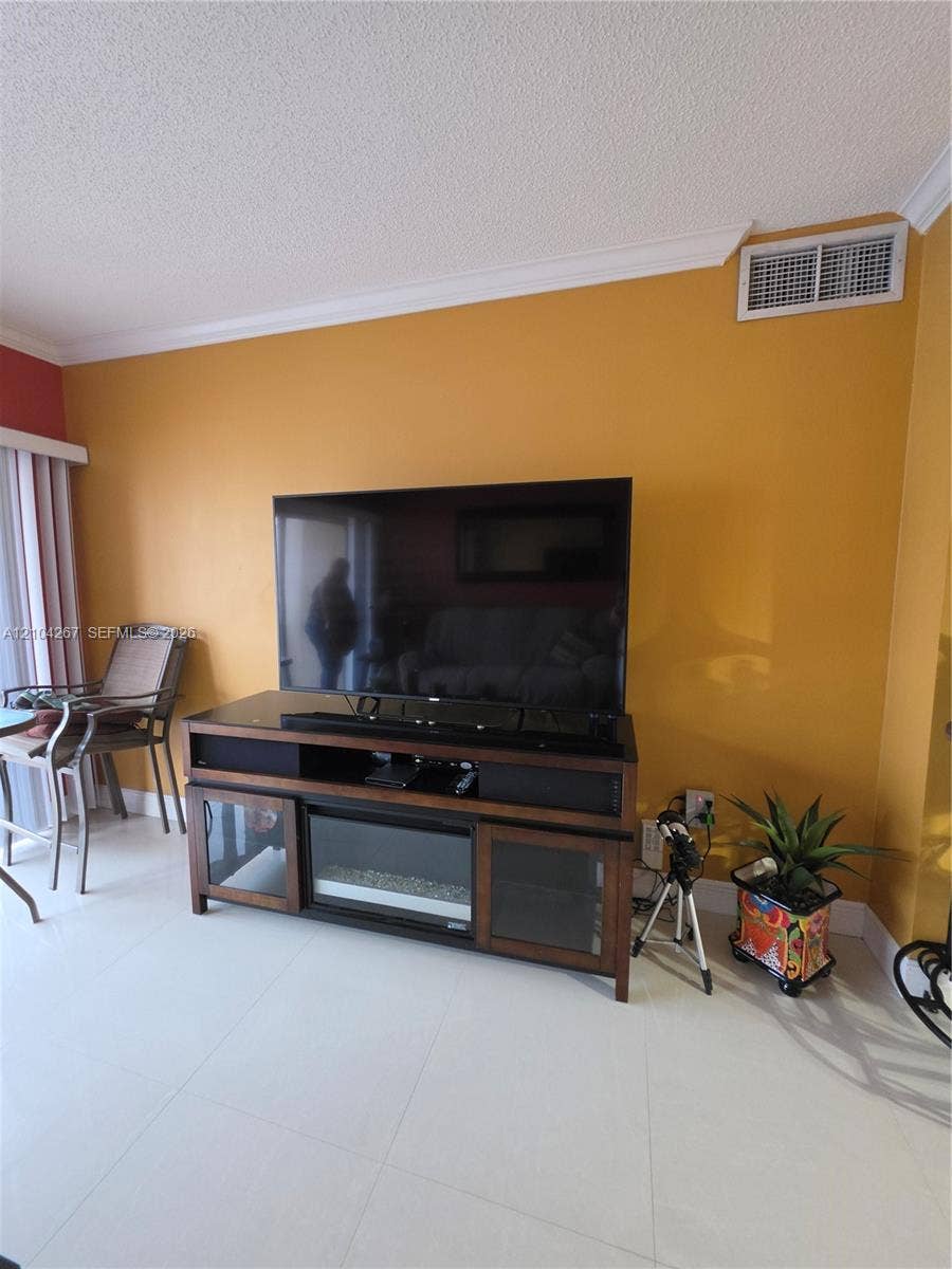 Interior space featuring large-format tile flooring and crown molding