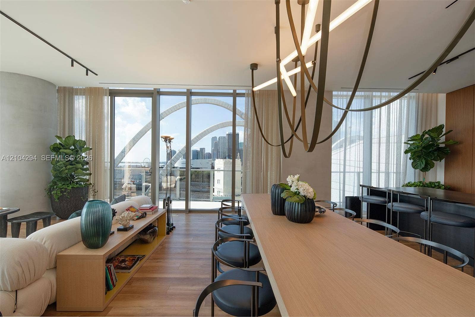 1400 Biscayne Boulevard, #1606, Miami, FL 33132 Open-concept living area featuring wood-finish flooring, floor-to-ceiling glass doors, and a linear track lighting system