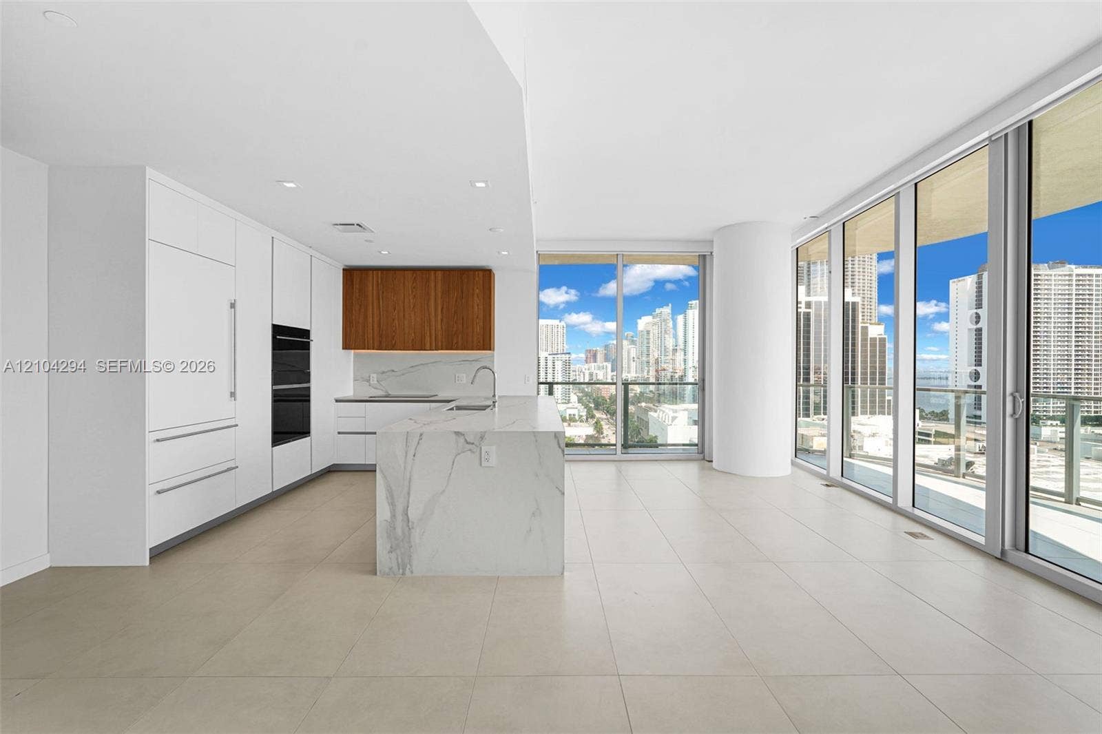 1400 Biscayne Boulevard, #1606, Miami, FL 33132 Open-concept kitchen with a waterfall island, integrated appliances, and wood-finish cabinetry