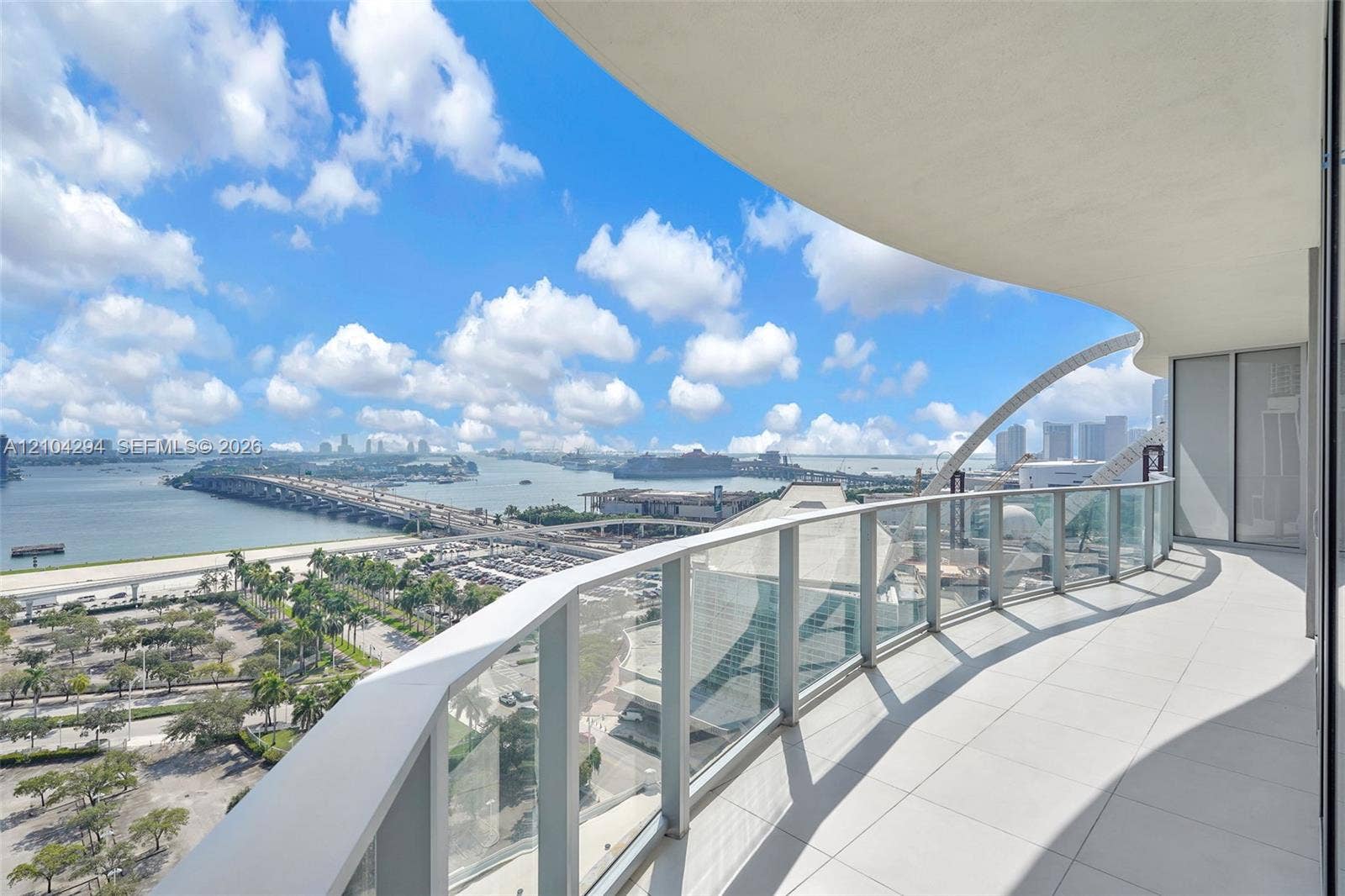 1400 Biscayne Boulevard, #1606, Miami, FL 33132 Expansive balcony with glass panel railings and a curved overhead architectural element