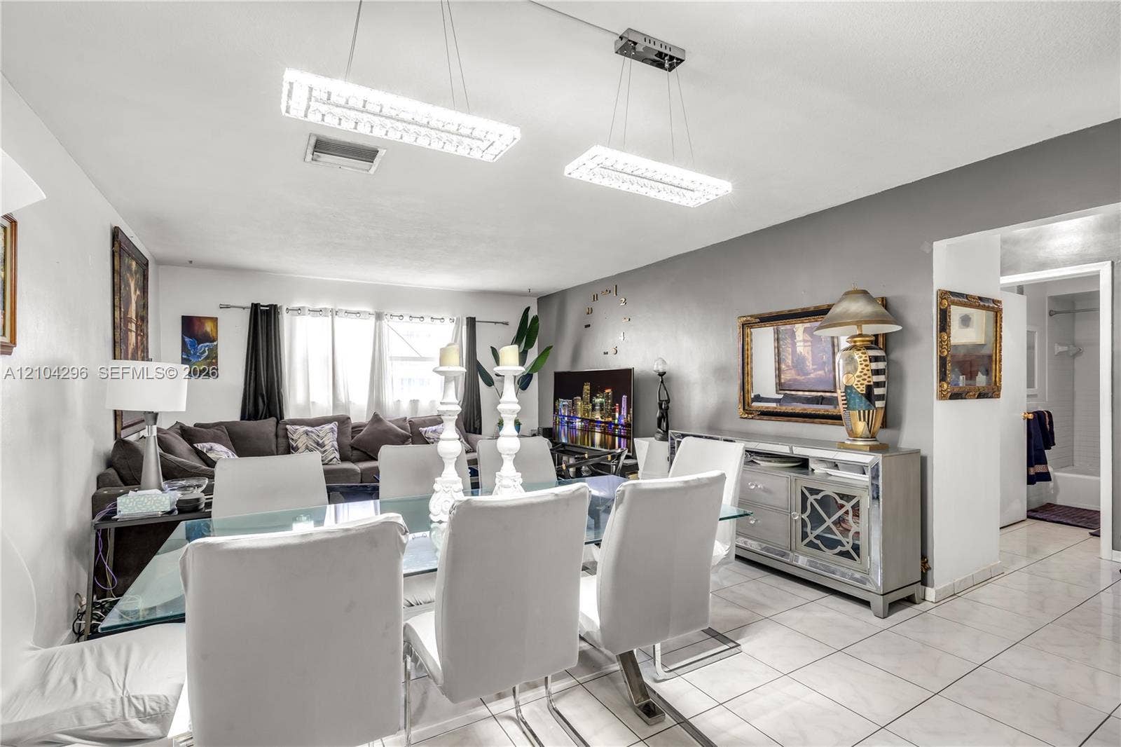 Large-format ceramic tile flooring, dual rectangular LED pendant lighting fixtures, and neutral interior paint palette