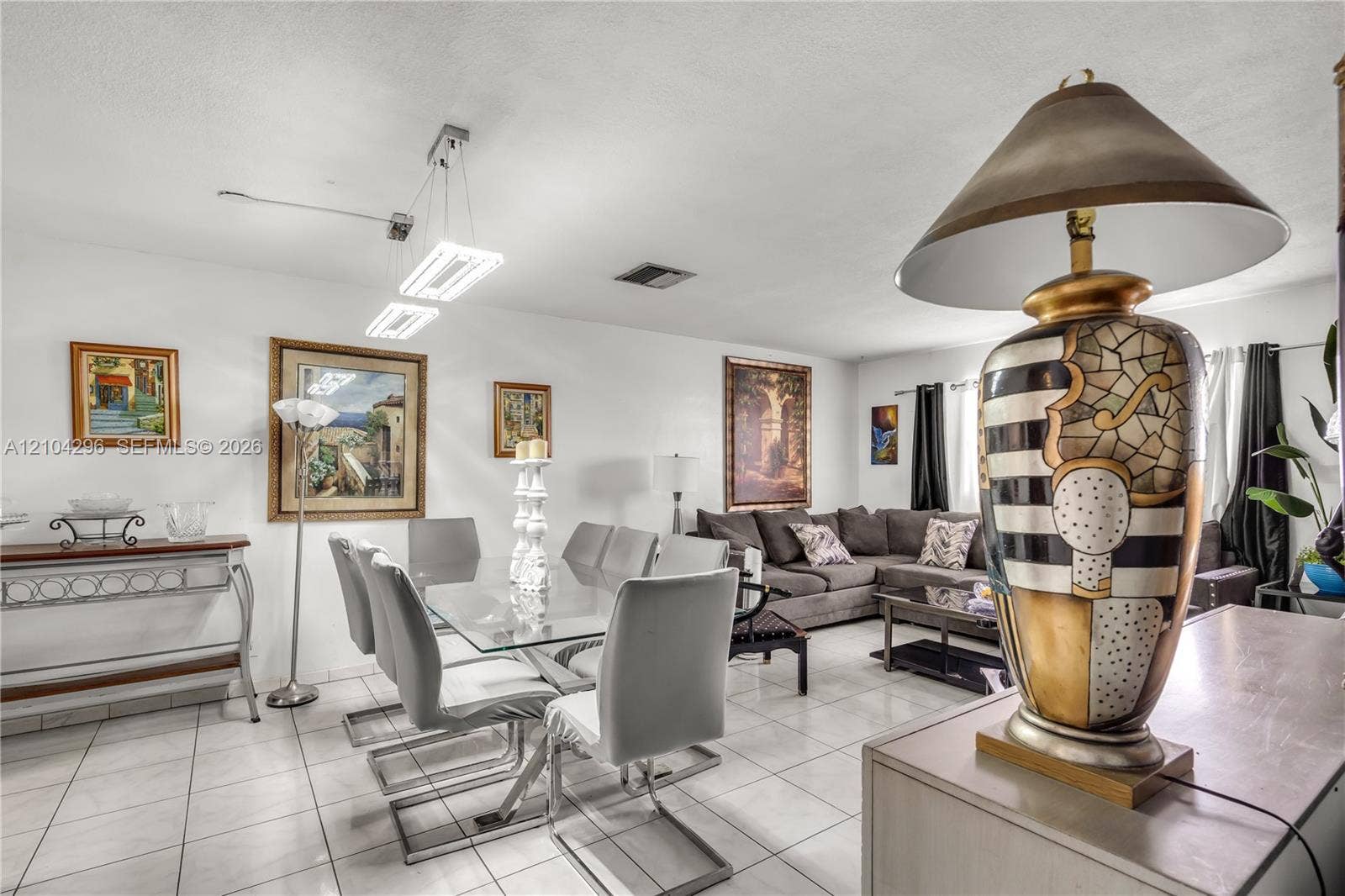 Open-concept interior featuring oversized tile flooring, modern dual-pendant rectangle lighting, and recessed ceiling lighting