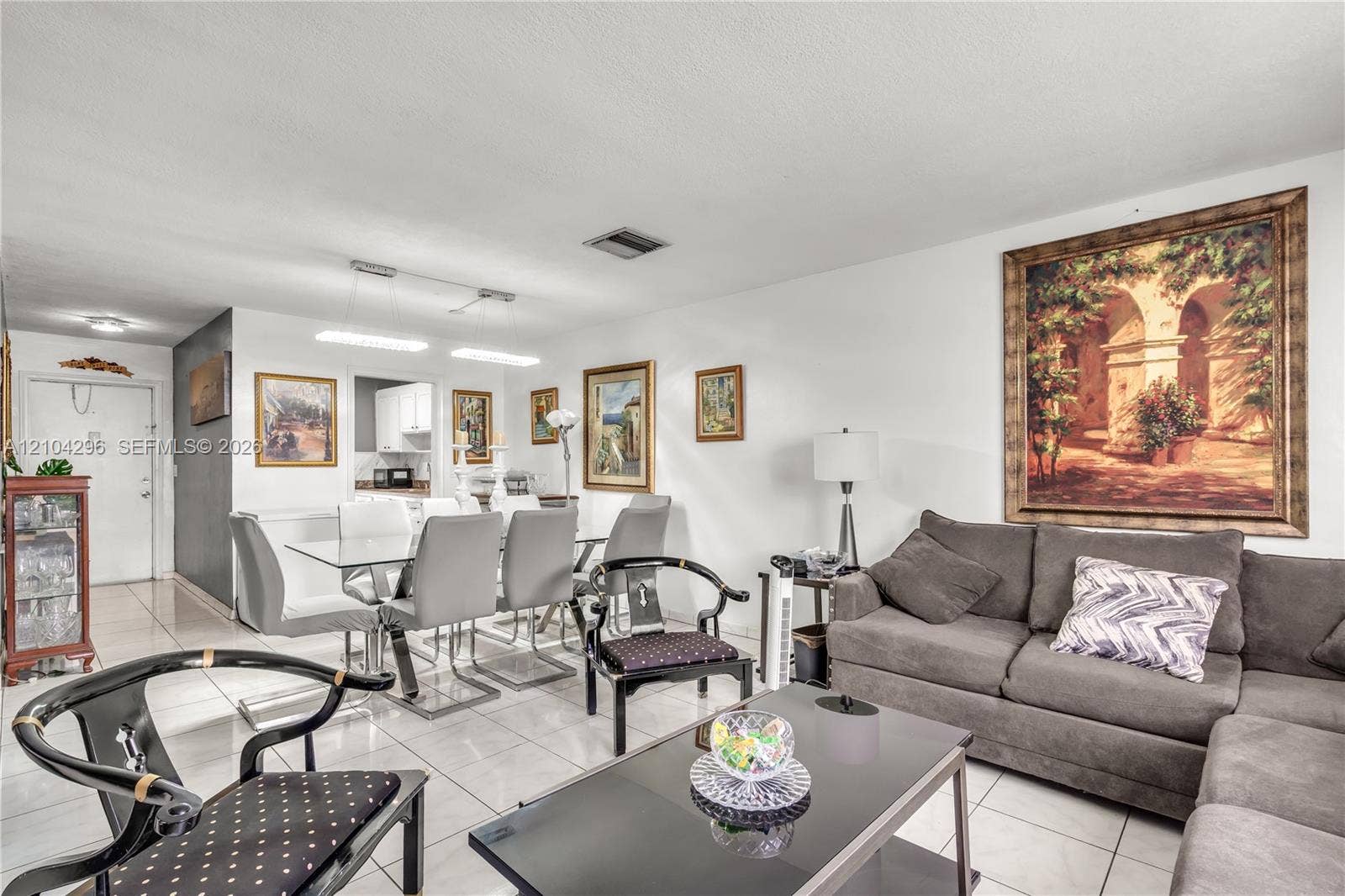 Open-concept interior featuring light-toned tile flooring, recessed ceiling lighting, and a neutral color palette