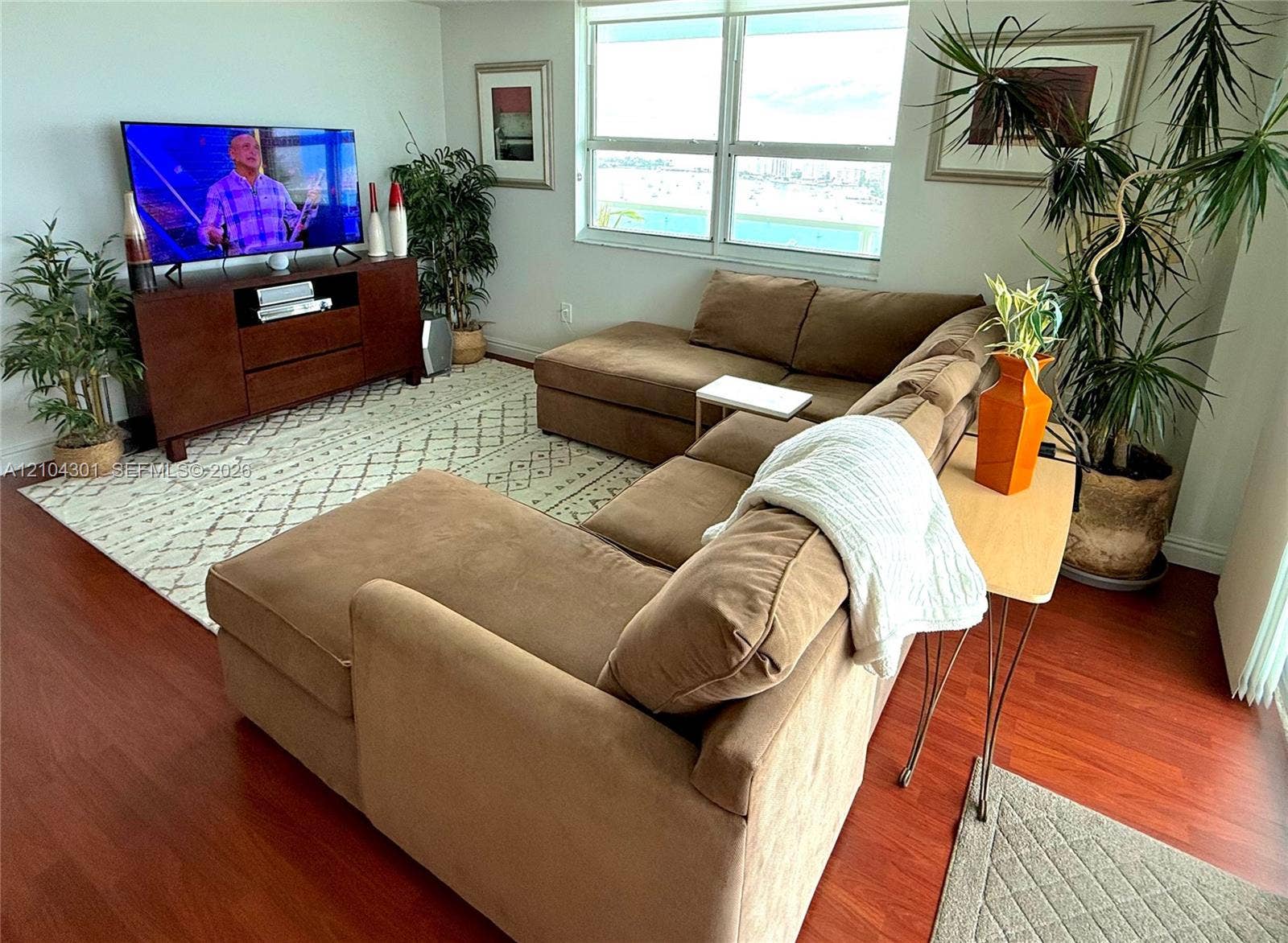 Living area featuring wood-finish flooring and large windows providing natural light