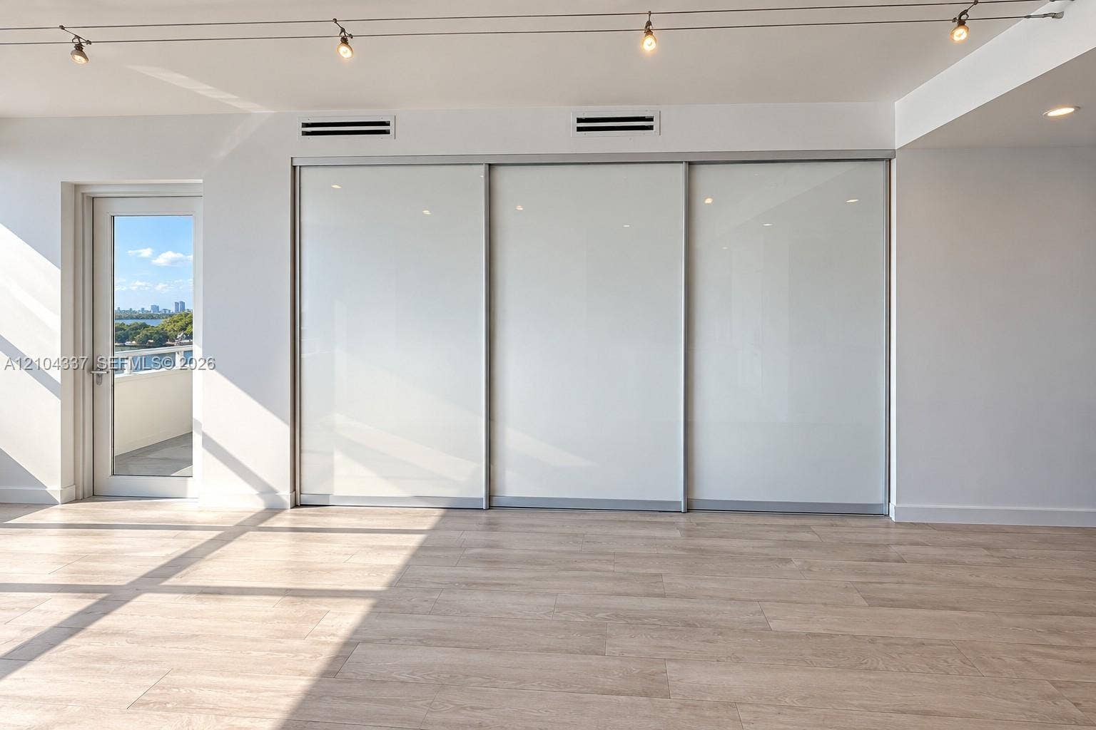 Versatile Den / Guest Suite  Virtually staged to illustrate two possible uses of the space: a private home office or guest bedroom. Floor-to-ceiling sliding glass panels allow for an open or enclosed layout.