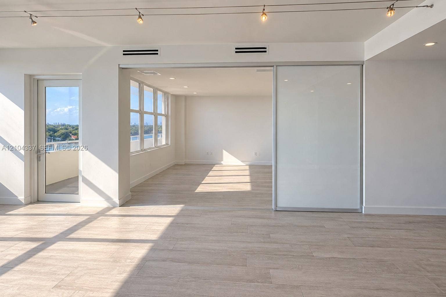 Versatile Den / Guest Suite  Virtually staged to illustrate two possible uses of the space: a private home office or guest bedroom. Floor-to-ceiling sliding glass panels allow for an open or enclosed layout.