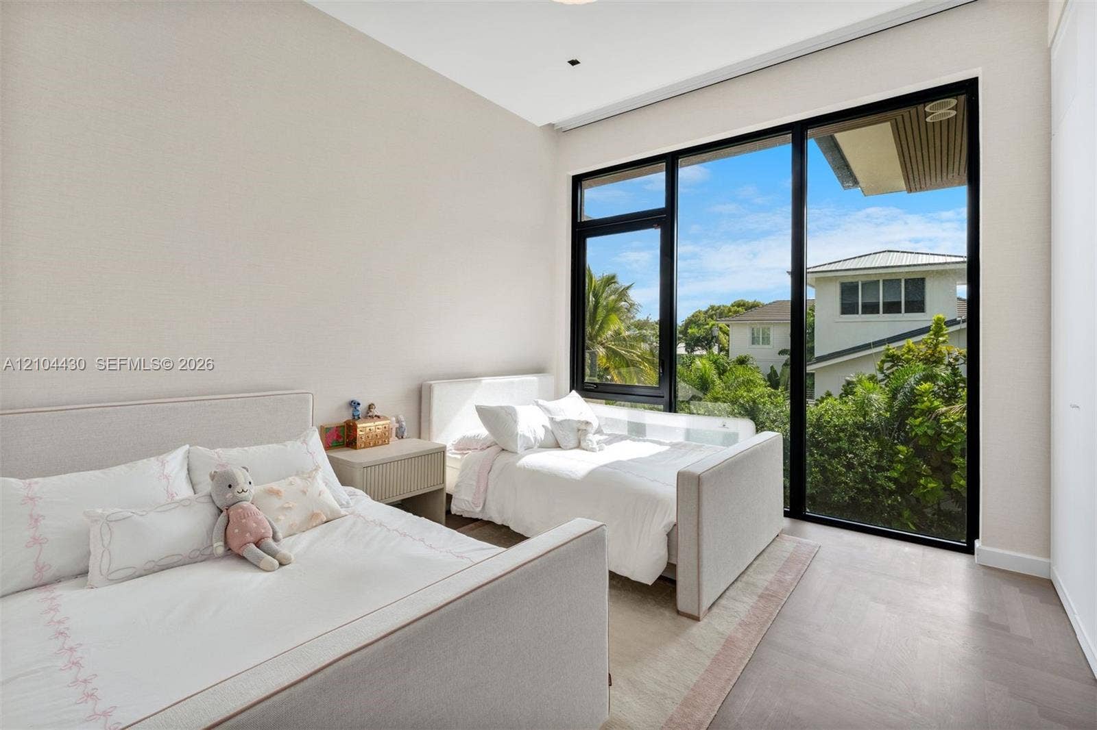 Floor-to-ceiling windows with black frames, wood-finish flooring, and recessed ceiling lighting
