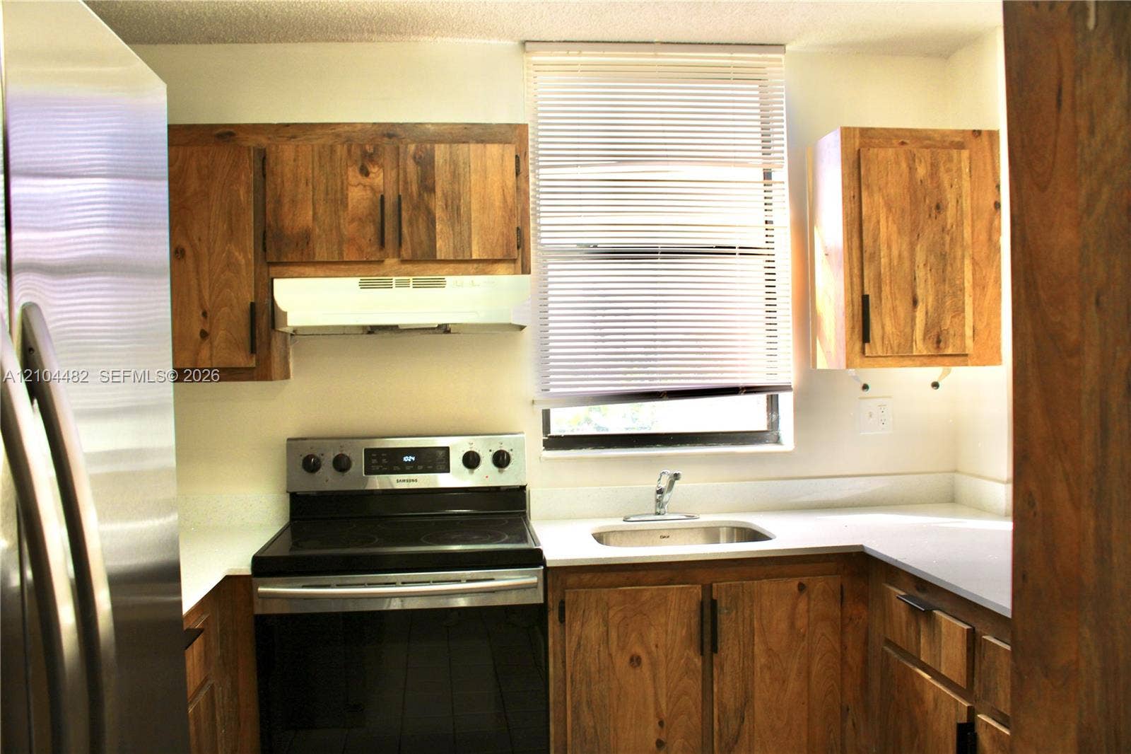 18000 NW 68th Avenue, #409A, Hialeah, Hialeah, FL 33015 stainless steel appliances, solid surface countertops, a stainless steel sink, and a window with horizontal blinds