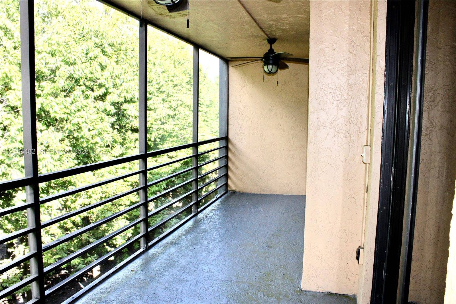 18000 NW 68th Avenue, #409A, Hialeah, Hialeah, FL 33015 Screened-in balcony featuring a concrete floor, metal railings, and a ceiling-mounted light fixture with a fan