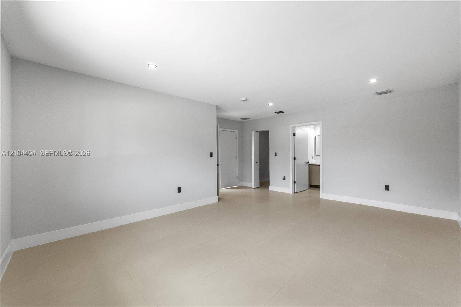 711 NW 8th Avenue, Dania Beach, FL 33004 Open interior space featuring neutral wall paint, large-format tile flooring, and recessed ceiling lighting