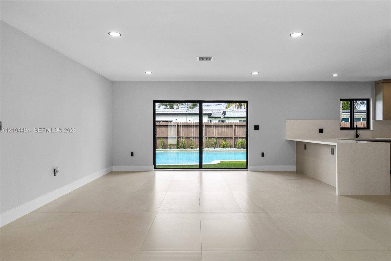 711 NW 8th Avenue, Dania Beach, FL 33004 Open-concept interior featuring large-format tile flooring, recessed lighting, and a kitchen island with a quartz countertop