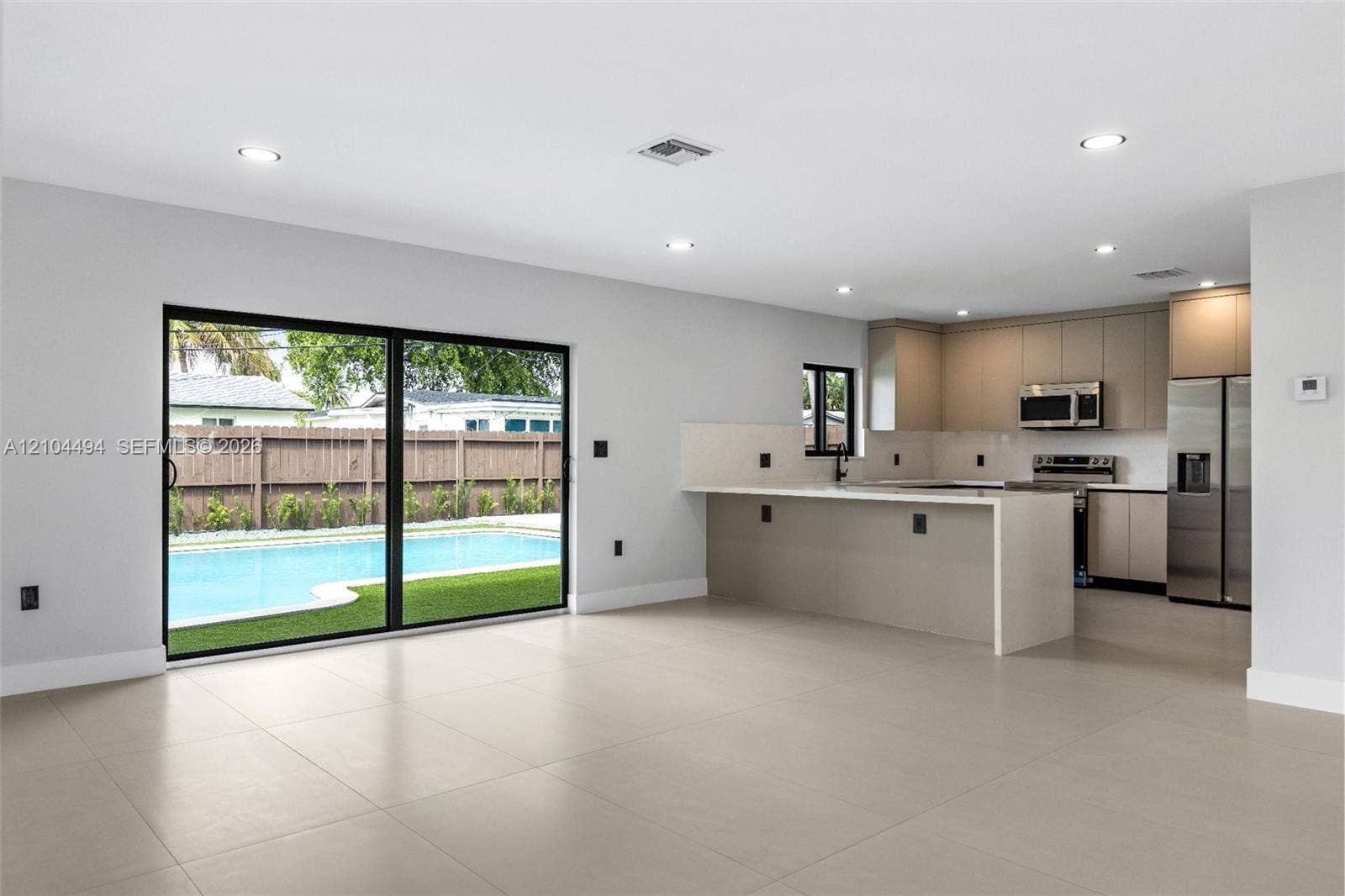 711 NW 8th Avenue, Dania Beach, FL 33004 Open-concept interior featuring large-format tile flooring, recessed lighting, and sliding glass doors