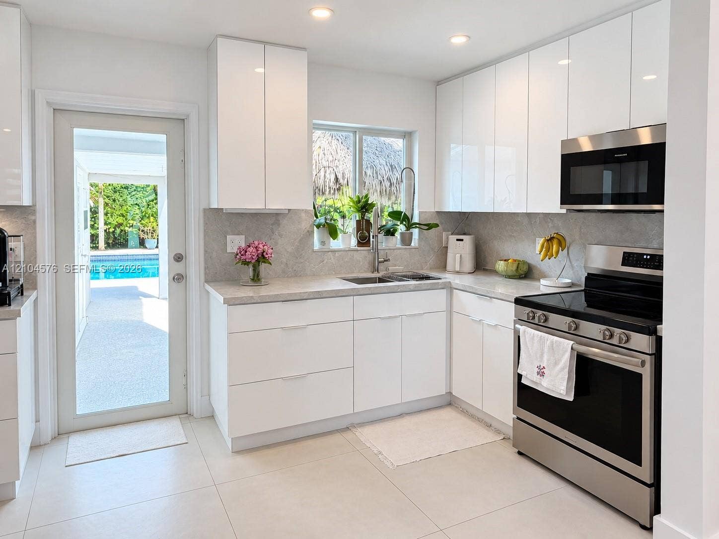 9755 SW 54th Street, Miami, Miami, FL 33165 Kitchen featuring high-gloss white cabinetry, stone-finish countertops, stainless steel appliances, recessed ceiling lighting, and a glass-paneled exterior door