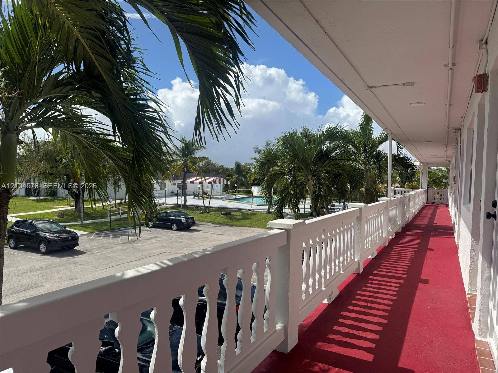 20320 NE 2nd Avenue, #22, Miami Gardens, Miami Gardens, FL 33179 Covered exterior balcony featuring a white balustrade railing and crimson floor surfacing