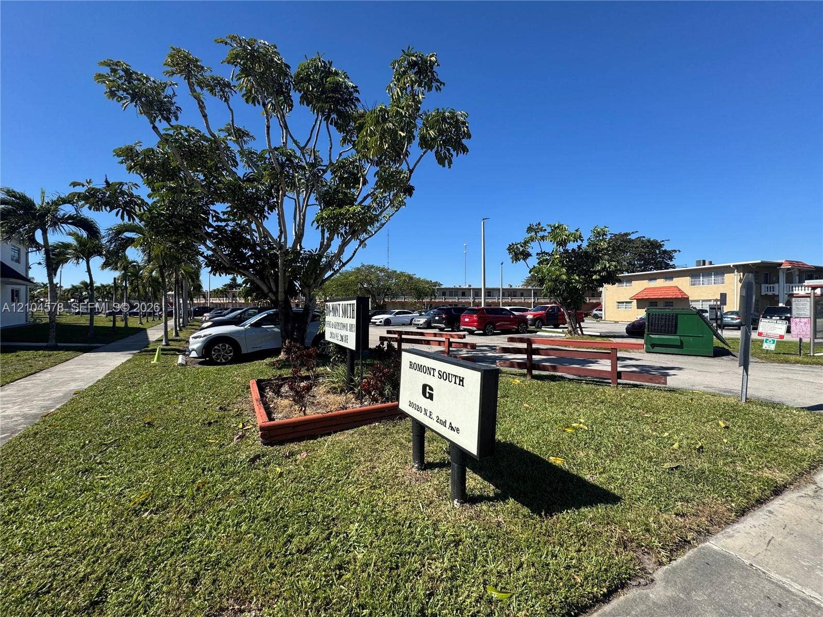 20320 NE 2nd Avenue, #22, Miami Gardens, Miami Gardens, FL 33179 Property exterior featuring paved parking areas, concrete walkways, mature landscaping, and signage