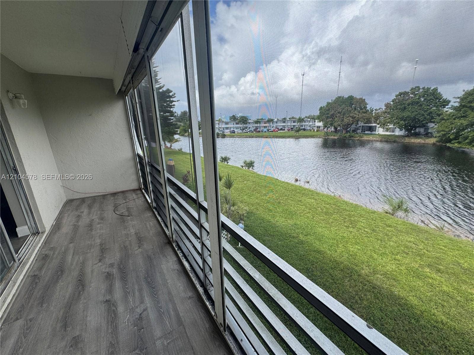 20320 NE 2nd Avenue, #22, Miami Gardens, Miami Gardens, FL 33179 Screened-in balcony featuring wood-finish flooring, metal railing, and direct water frontage
