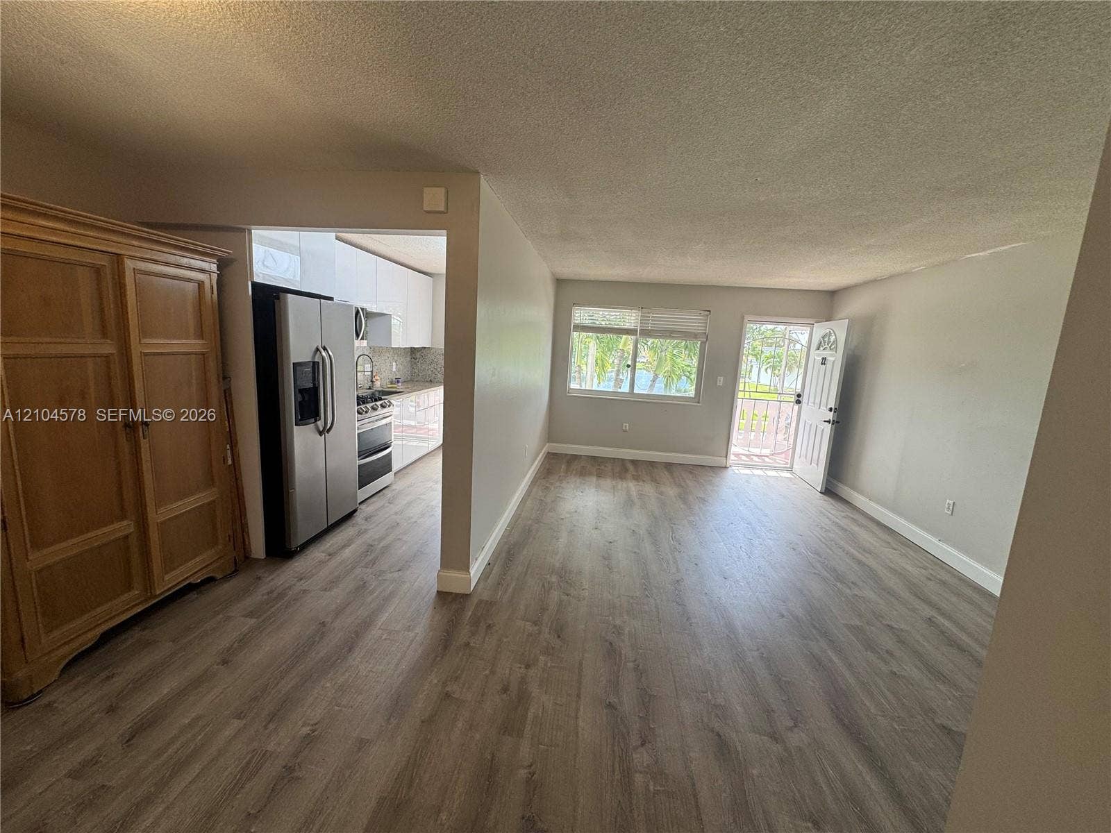 20320 NE 2nd Avenue, #22, Miami Gardens, Miami Gardens, FL 33179 Kitchen featuring gloss-finish cabinetry, stainless steel refrigerator and range, stone-surface countertops, and wood-finish flooring