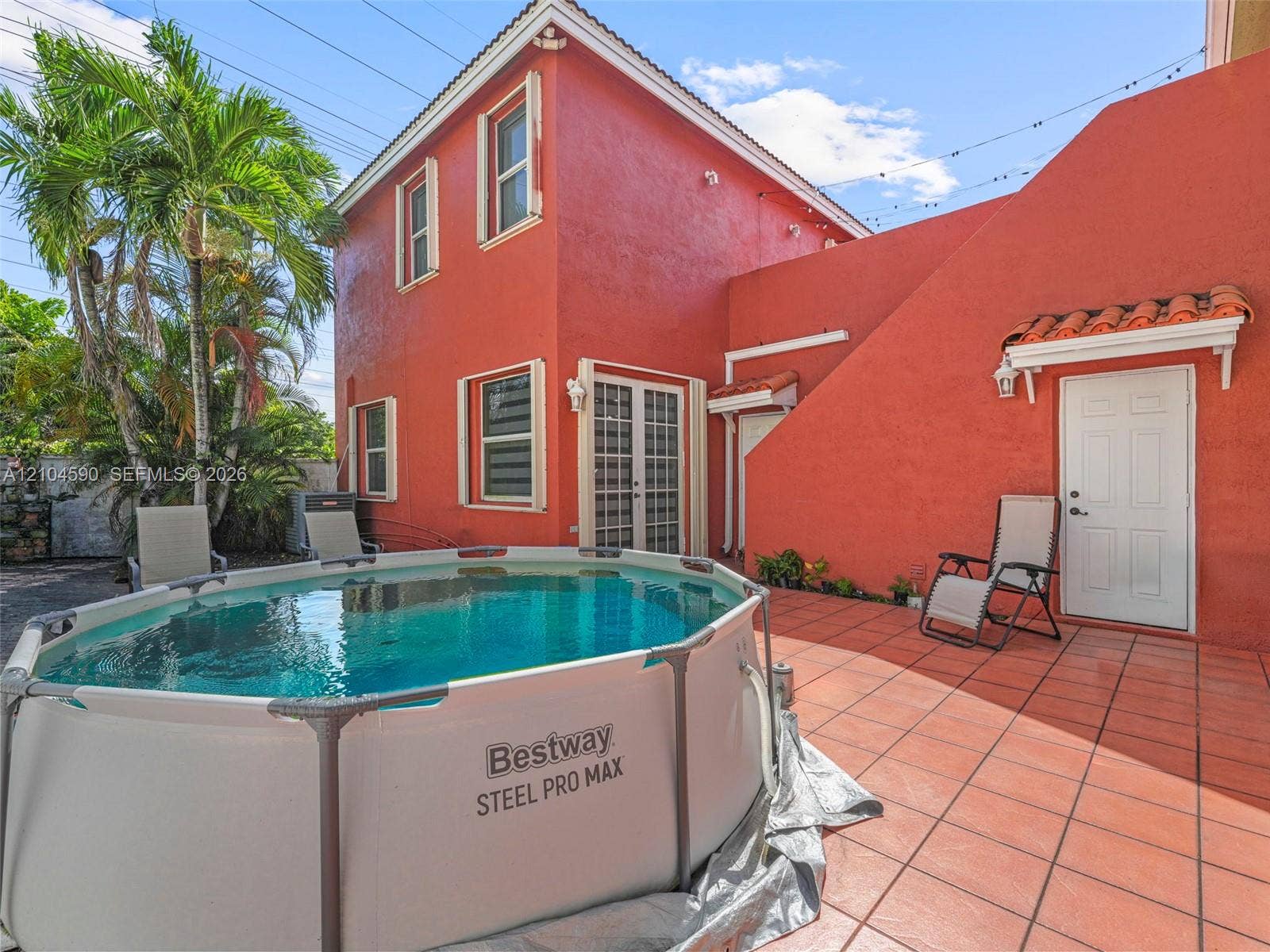 Stucco exterior featuring a tiled patio and multiple points of entry