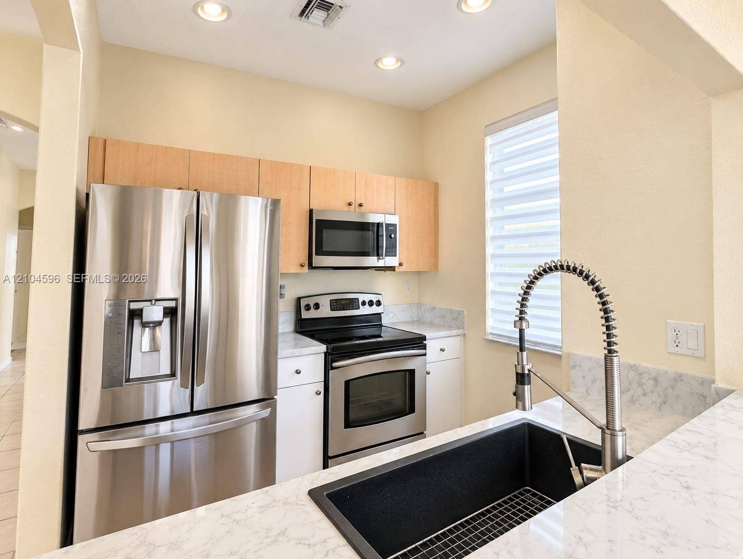 10968 SW 236th Terrace, Homestead, Homestead, FL 33032 Kitchen featuring stainless steel appliances, light wood-finish cabinetry, stone-patterned countertops, a deep undermount sink with a gooseneck faucet, and recessed lighting