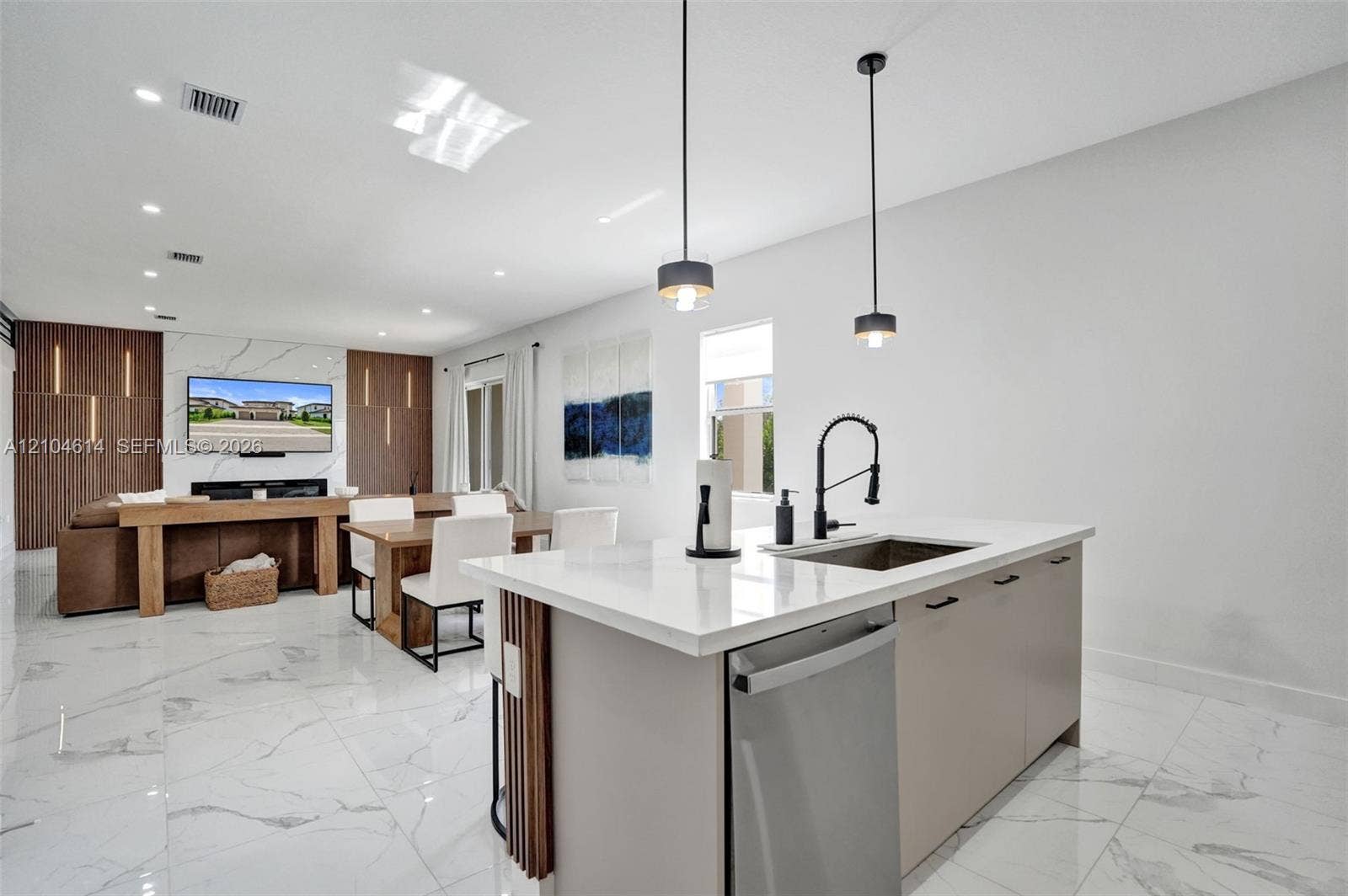 12240 SW 44th Court, Davie, FL 33330 Kitchen island with a built-in sink and stainless steel dishwasher, white countertop, and pendant lighting