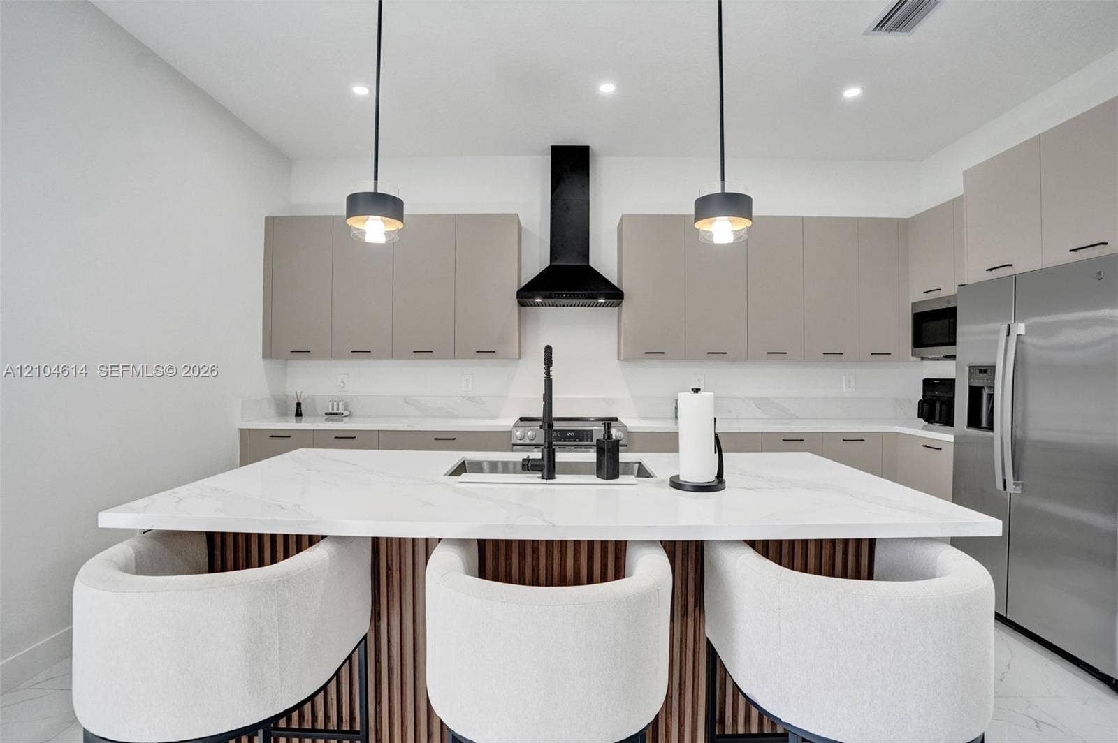 12240 SW 44th Court, Davie, FL 33330 Kitchen featuring a large island with white countertop, integrated sink, and wood-slat detailing