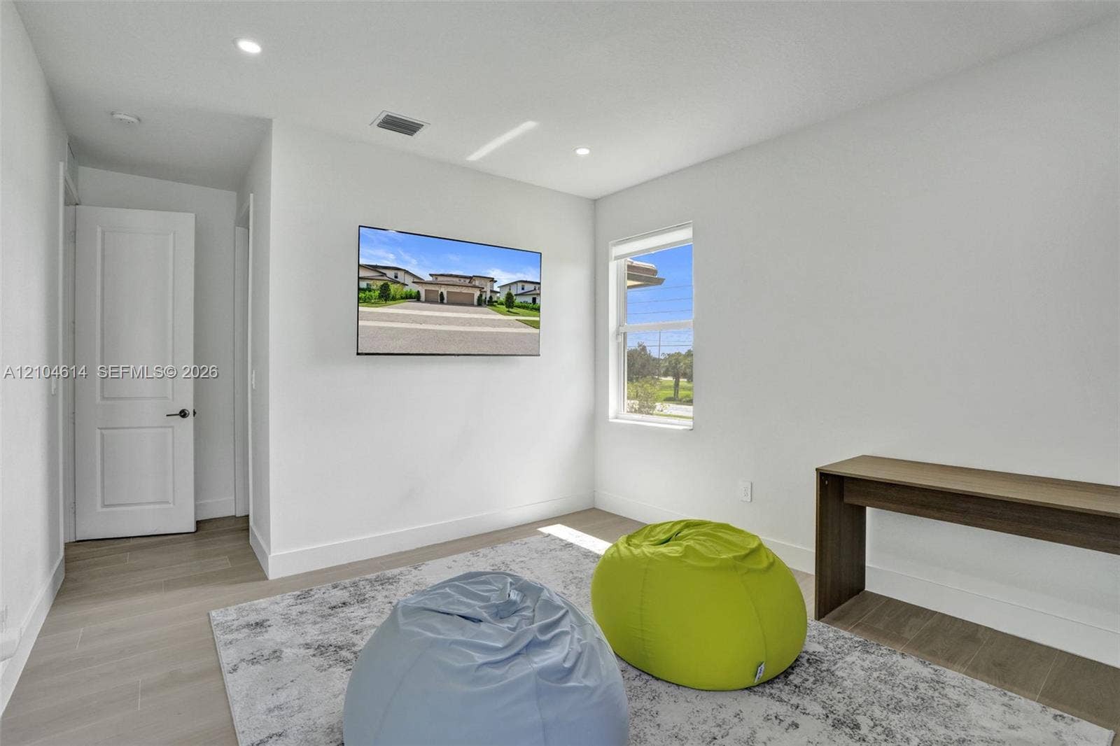 12240 SW 44th Court, Davie, FL 33330 Recessed lighting, wood look flooring, white walls, built-in shelving, and a single window