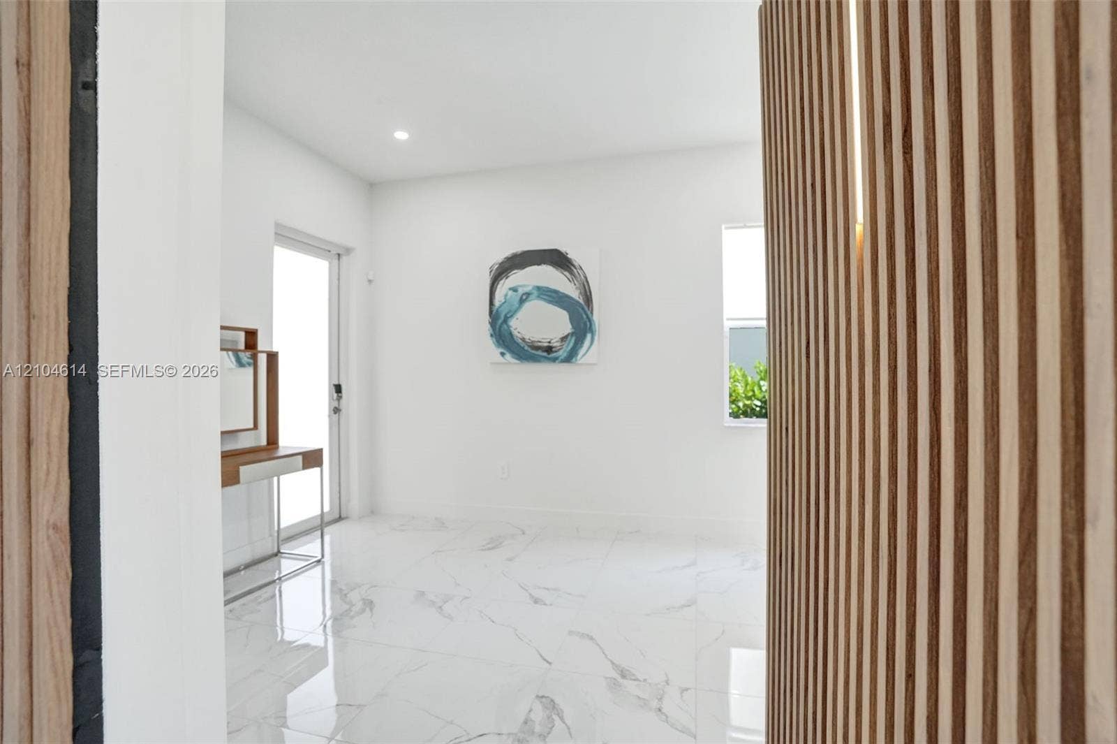 12240 SW 44th Court, Davie, FL 33330 Wood slat wall paneling with integrated lighting, white walls, large format tile flooring, and a sliding glass door