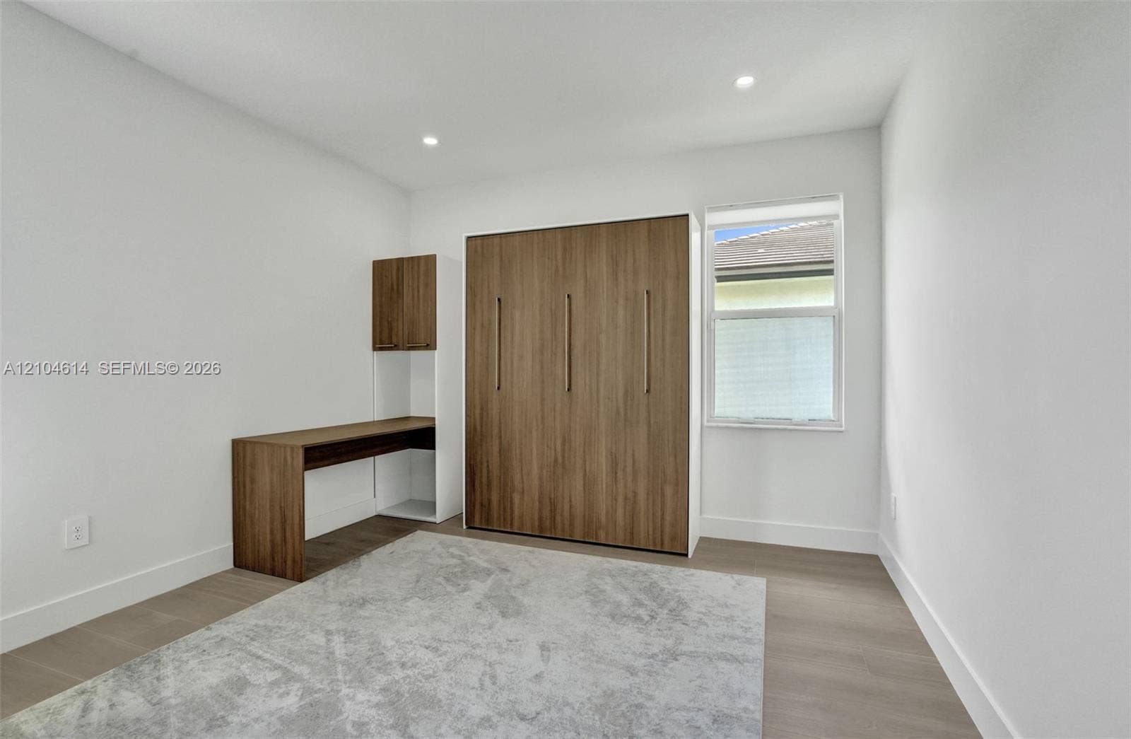 12240 SW 44th Court, Davie, FL 33330 Recessed ceiling lighting, wood look flooring, built-in desk with overhead cabinetry